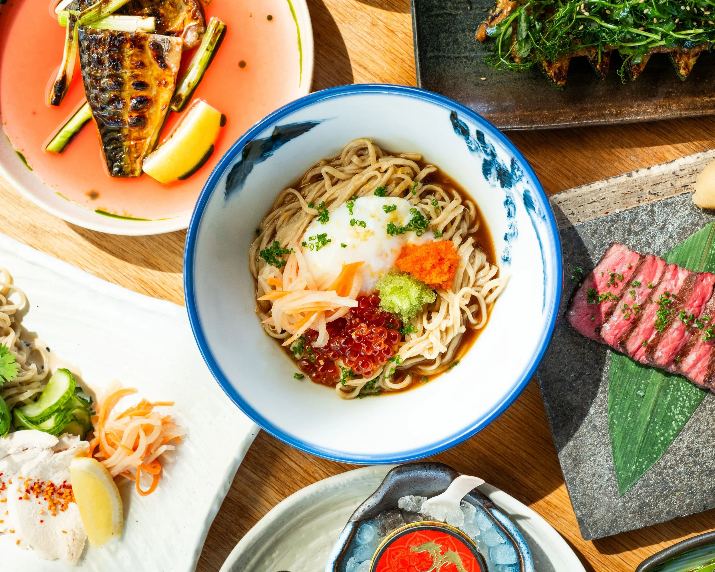 A table spread of food dishes from AFURI IZAKAYA