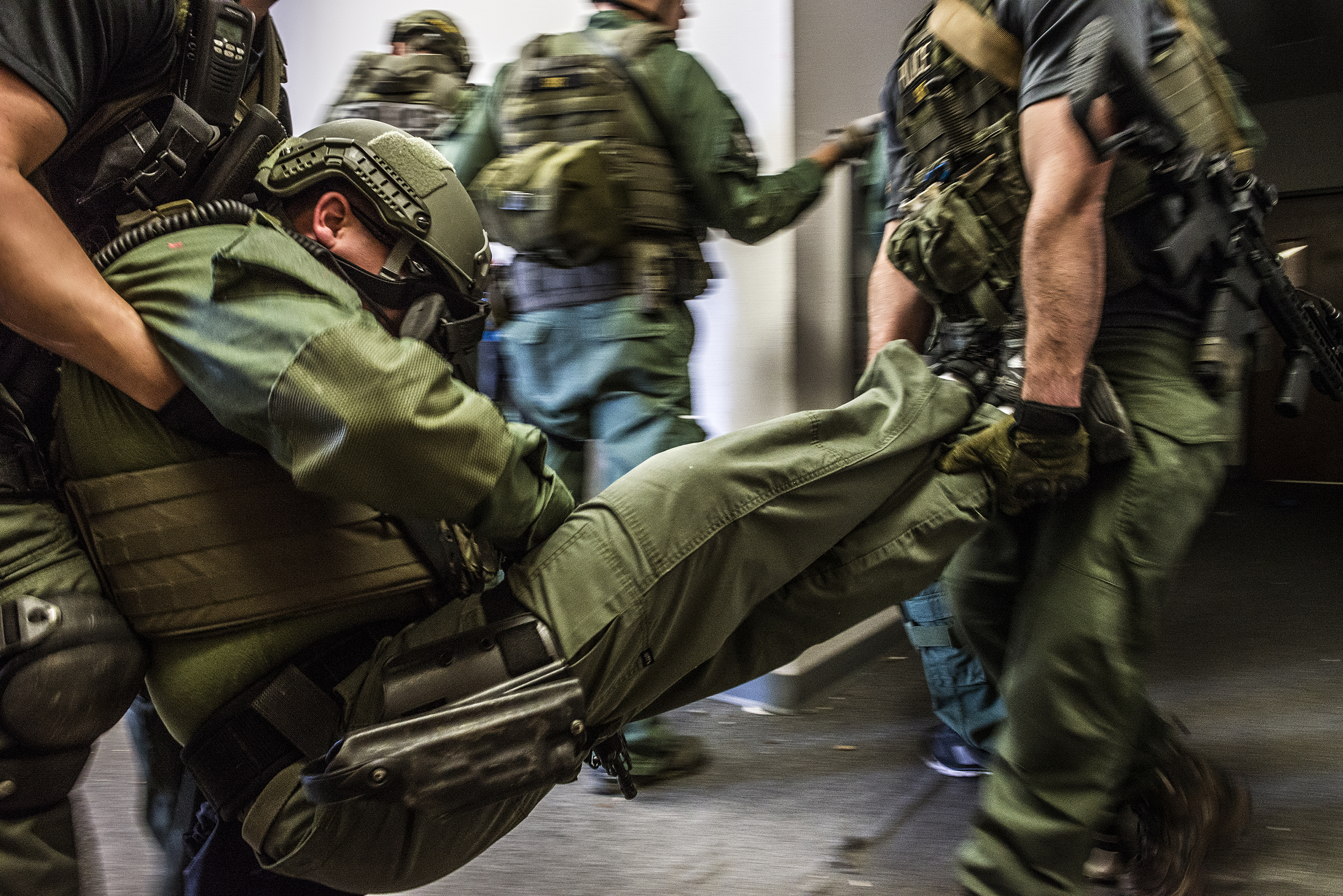  After a simulated IED explosion eliminates an officer, police carry him from a training facility near Mansfield, TX.  Due to funding and manpower constraints, the Southwest Regional Response Group, composed of suburban police officers, was created f