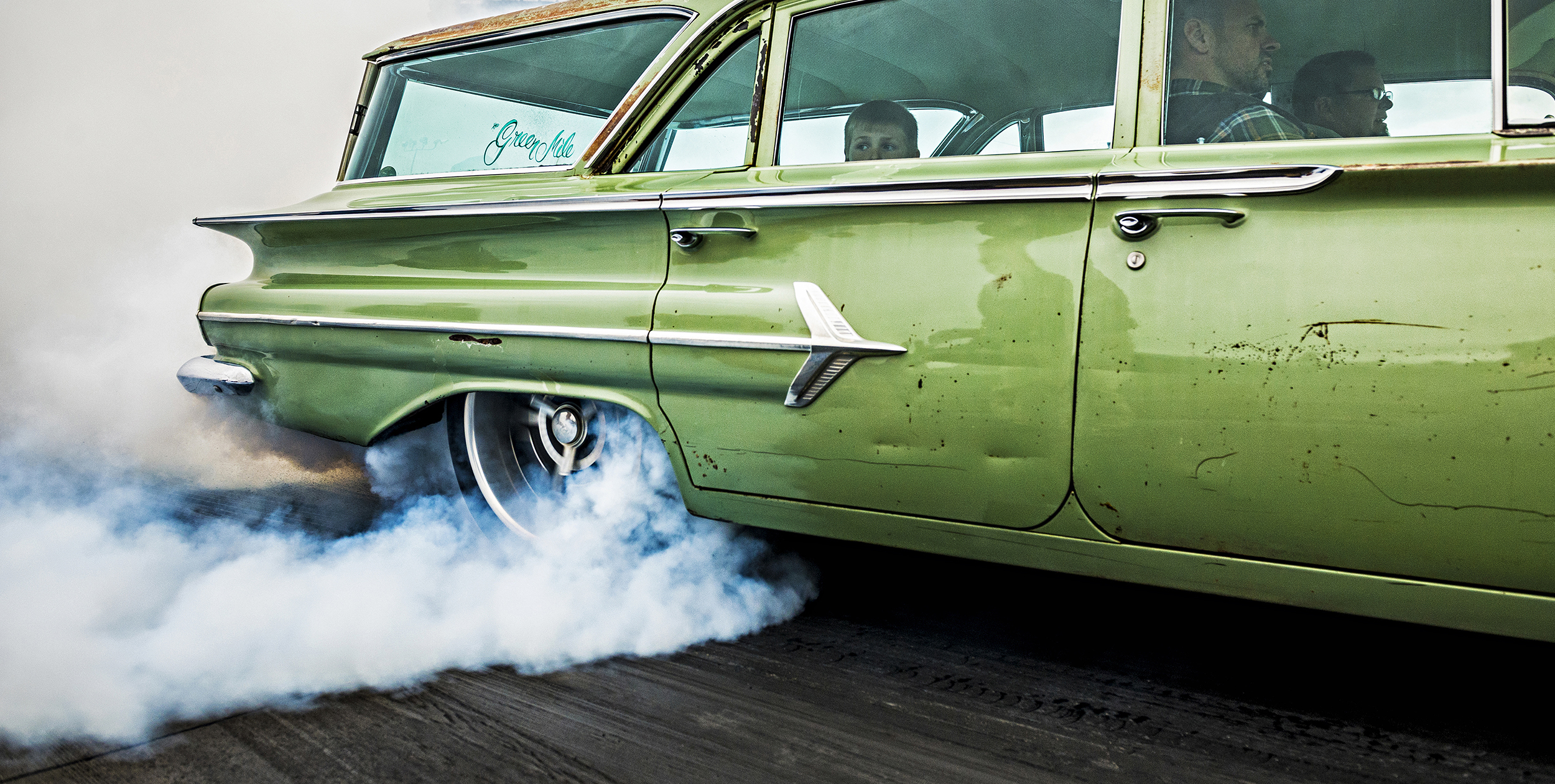  A child peers from the backseat of a souped up 1960 Chevy Parkwood Wagon as it tears down the drag strip at Northstar Dragway in Denton, TX during a wake for racer Blake Williams.  In December 2016, Williams was killed in a fiery crash at Yello Bell