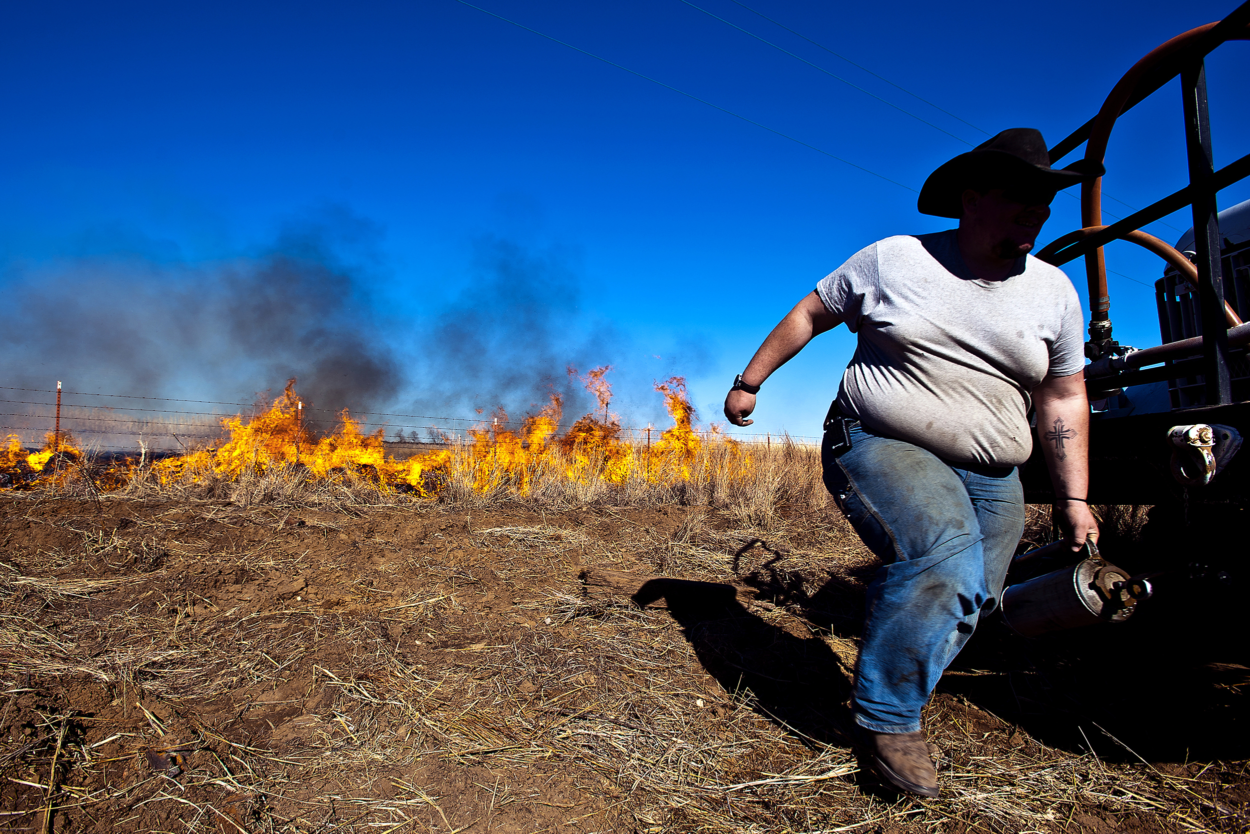 Yancey Heugatter runs to man a water hose as a salvage burn goes wild near Bowie, TX.  Several acres were left charred before firefighters from neighboring communities responded to extinguish the blaze. 