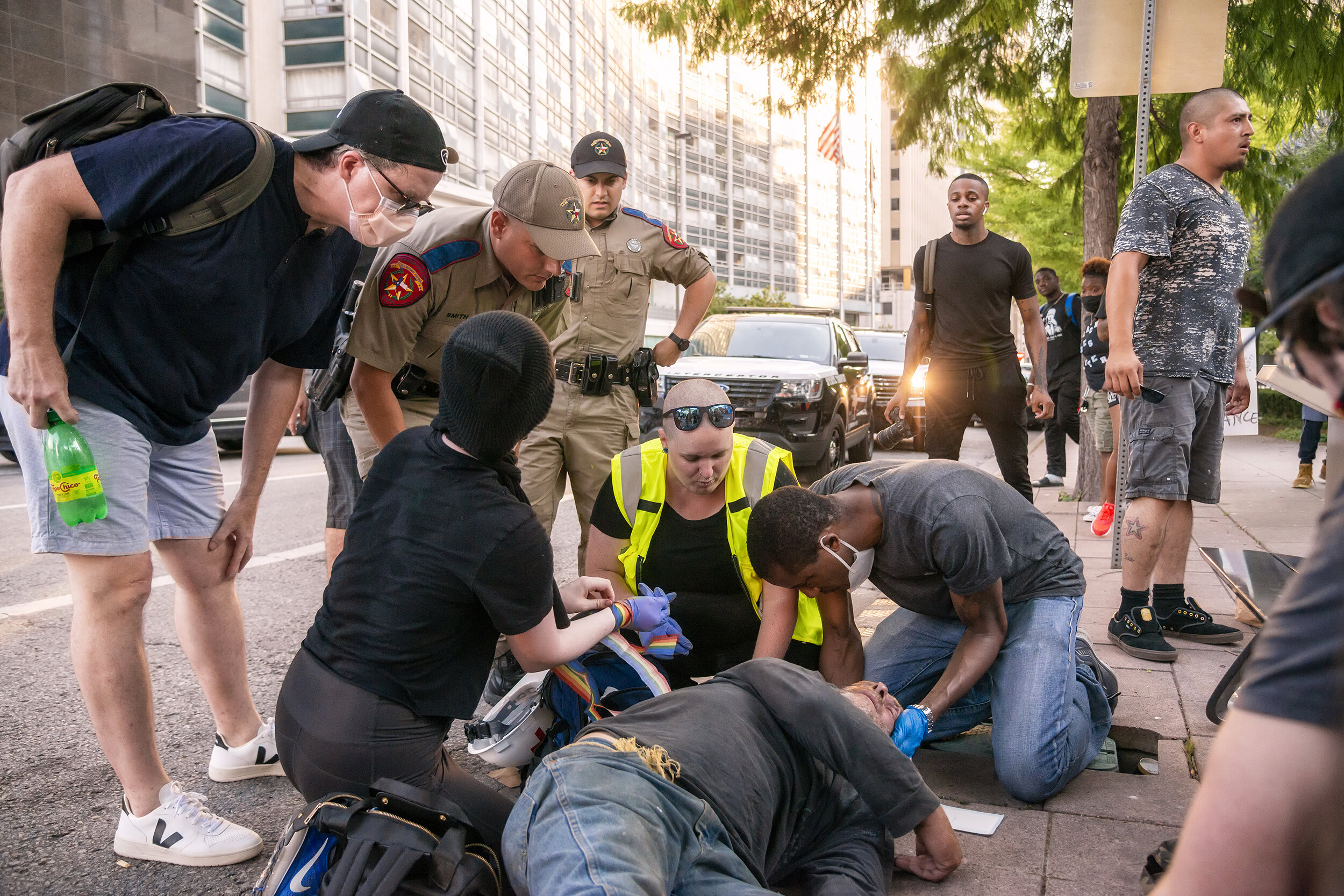  Law enforcement and anti-police brutality protesters work together to stabilize a man after a tangential assault left him unconscious and bleeding near Main Street Garden Park in Dallas, TX on June 6, 2020.  The unconscious man had been attacked and