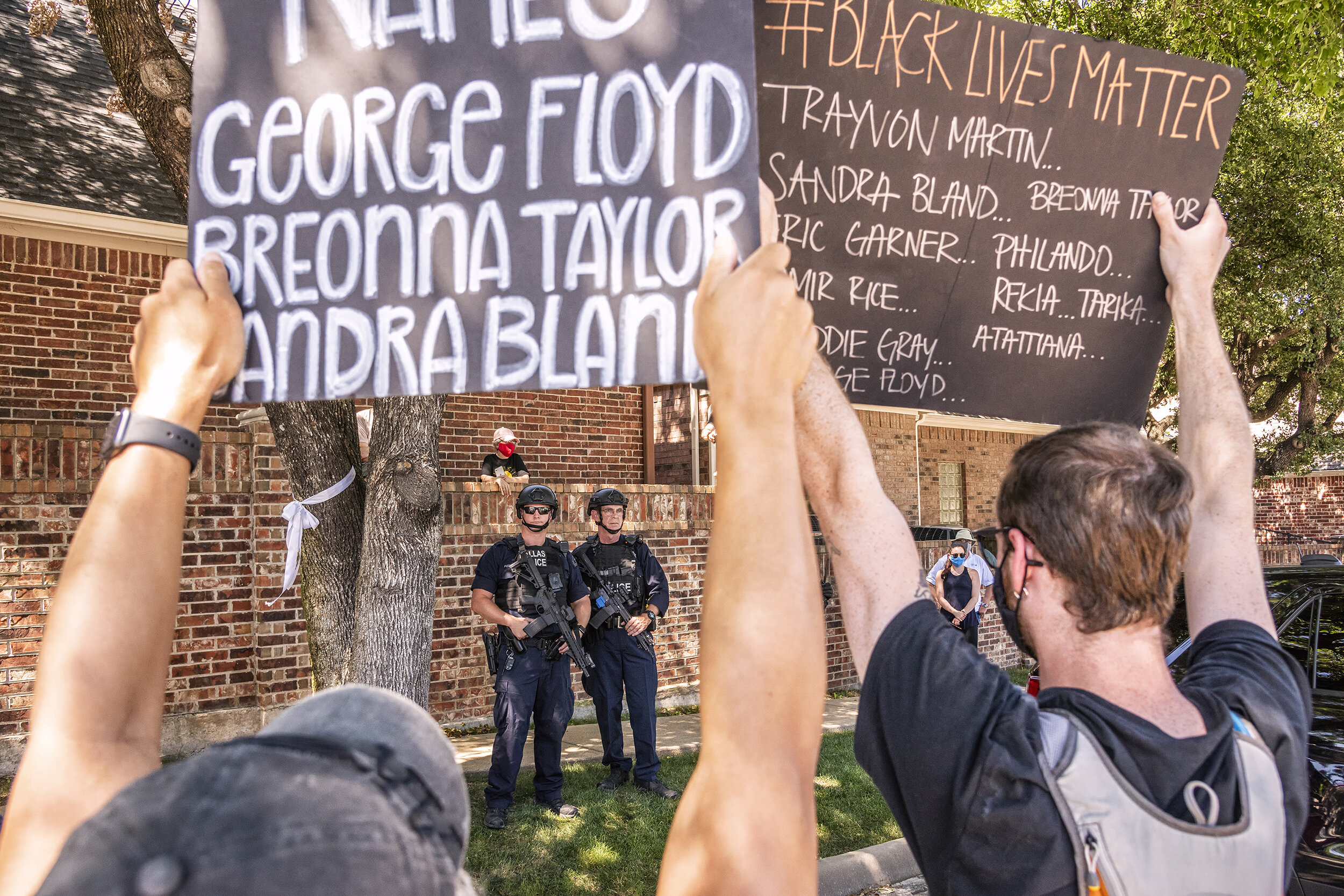  In the Preston Hollow neighborhood of Dallas, TX on June 11, 2020, protesters confront law enforcement with signs bearing names of Black Americans who died in police custody.  The protest coincided with President Donald Trump’s visit to Gateway Chur