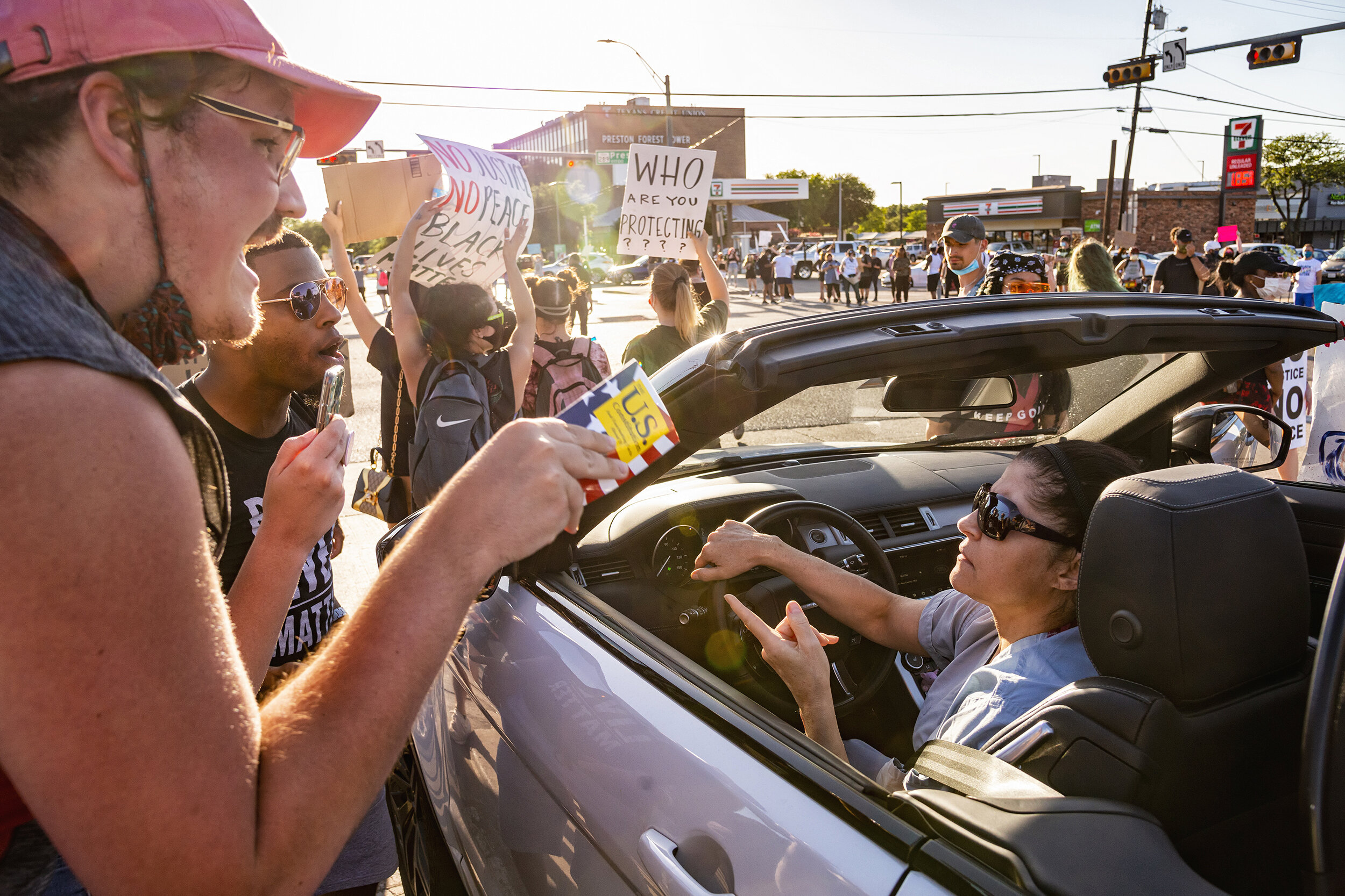  A protester holding the U.S. Constitution trades words with a motorist at Forest Lane and Preston Road in the Preston Hollow neighborhood of Dallas, TX on June 11, 2020.  Protesters shut down the busy intersection in an act of civil disobedience aim