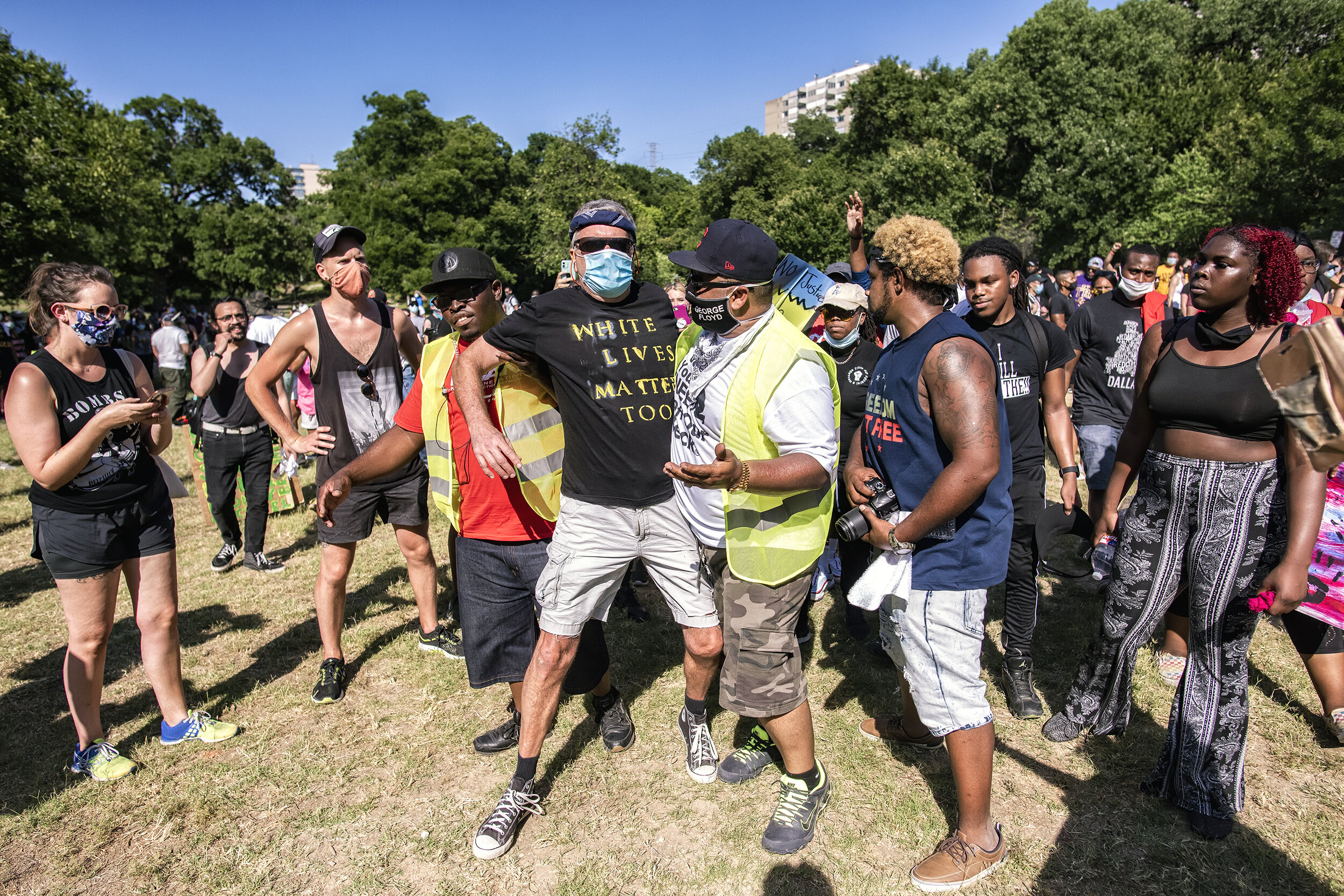  A man wearing a T-shirt reading “white lives matter too” is ejected from the Black State of Emergency protest at Reverchon Park in Dallas, TX on June 13, 2020.  The slogan was seen by many as an affront to the Black Lives Matter movement. 