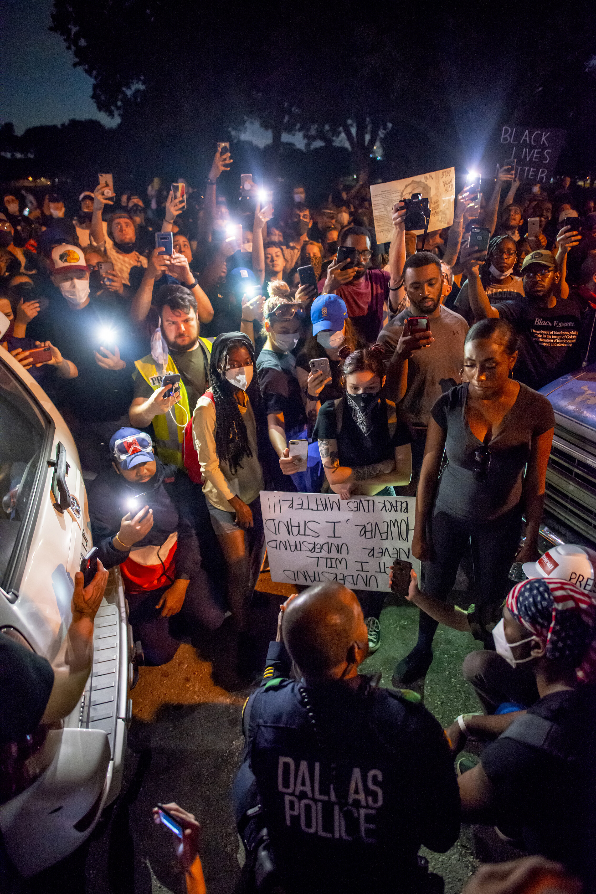  Dallas Police Sgt. Ira Carter takes a knee with protesters at Lake Cliff Park in the Oak Cliff neighborhood of Dallas, TX on June 2, 2020.  Carter expressed support for the protesters but cautioned them to remain peaceful.  Unlike previous nights of