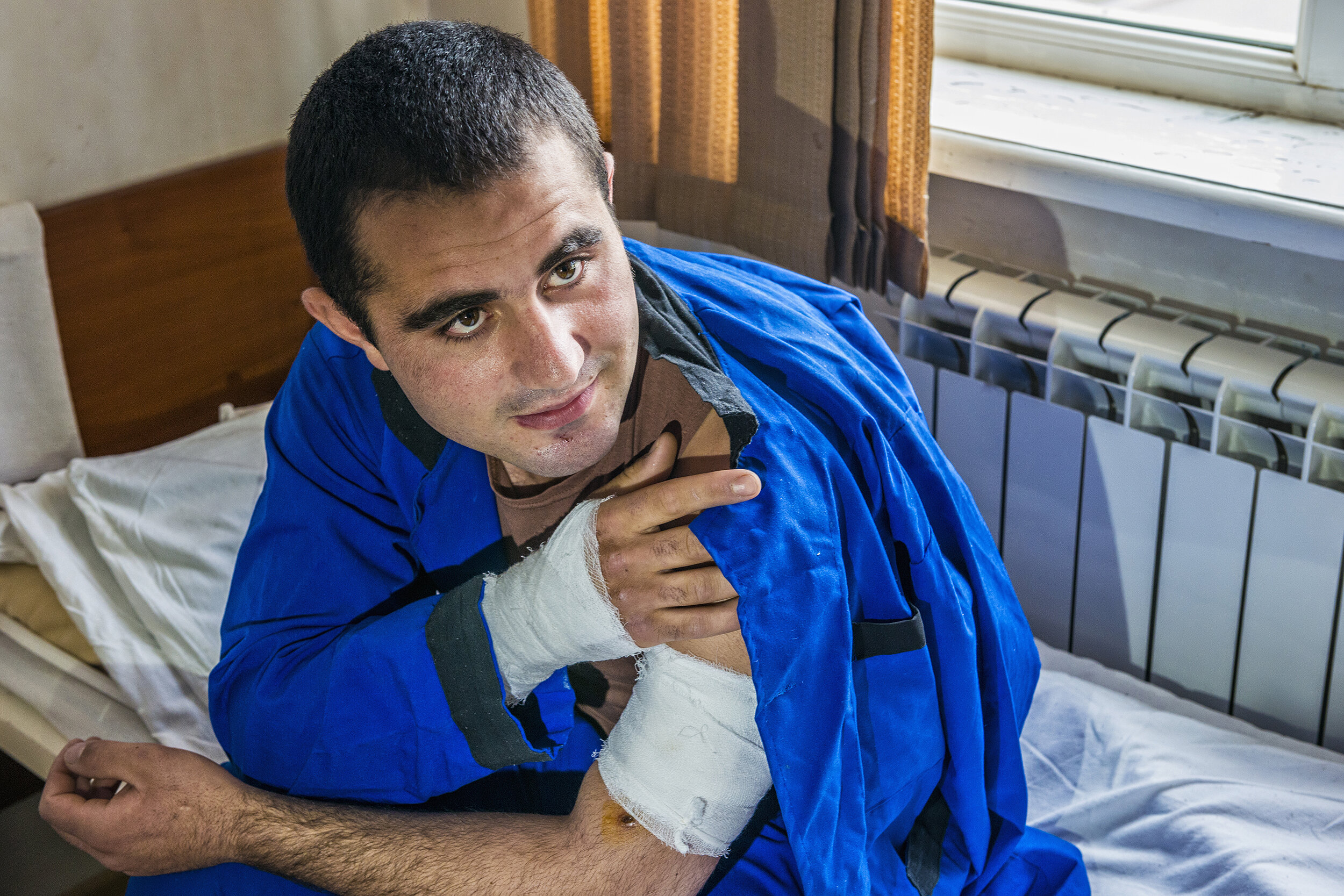  An NKR soldier peppered by shrapnel from an artillery shell during the Four-Day War shows his bandaged wounds to a TV crew at Stepanakert Central Military Hospital in Nagorno-Karabakh.  The hospital ward housed several soldiers wounded by artillery,