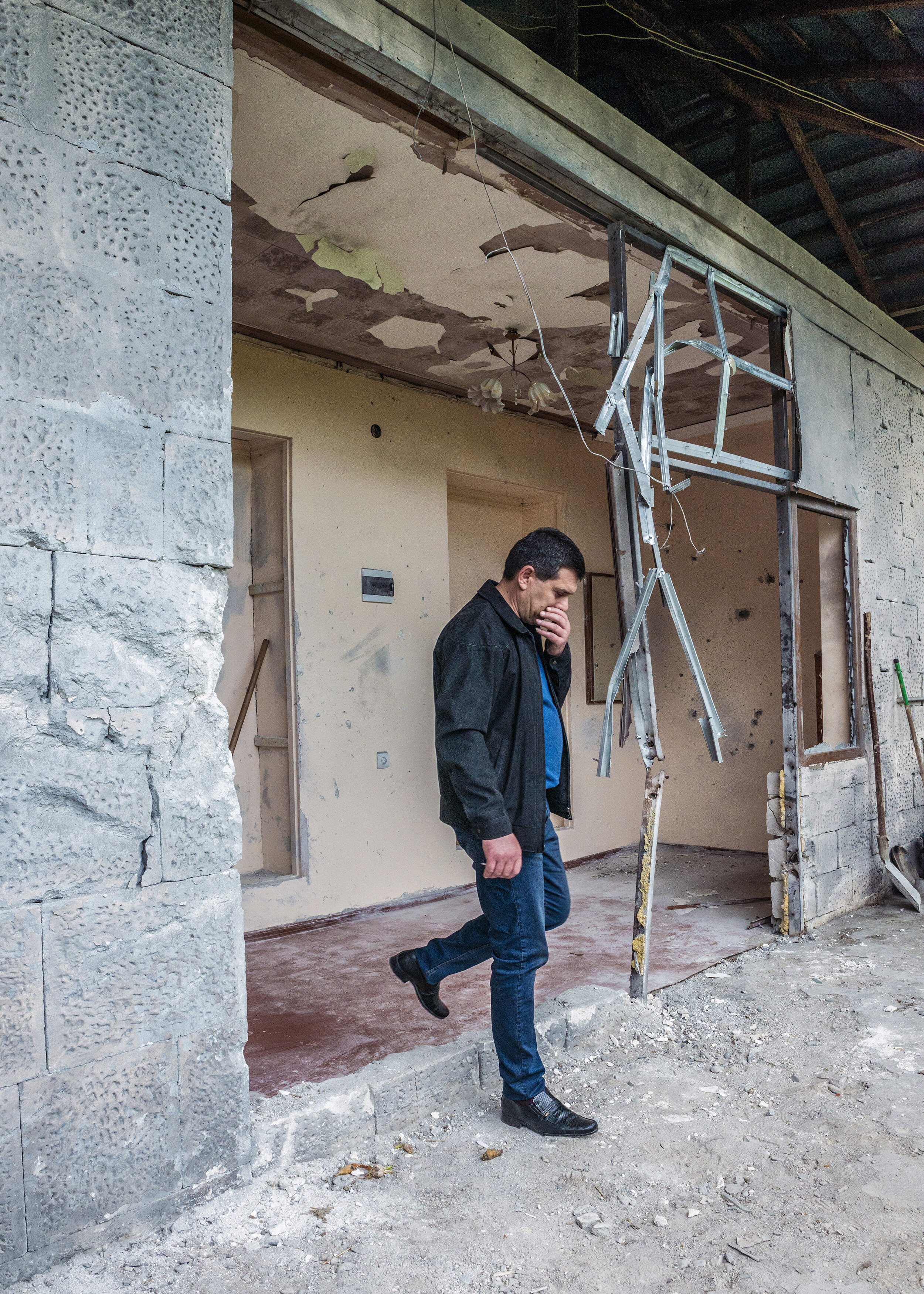  A resident of Martakert, Nagorno-Karabakh steps from his home, which he said was hit by an Azerbaijani artillery shell while he and his wife were at a local restaurant at the start of the Four-Day War.  Martakert, situated less than two miles from t