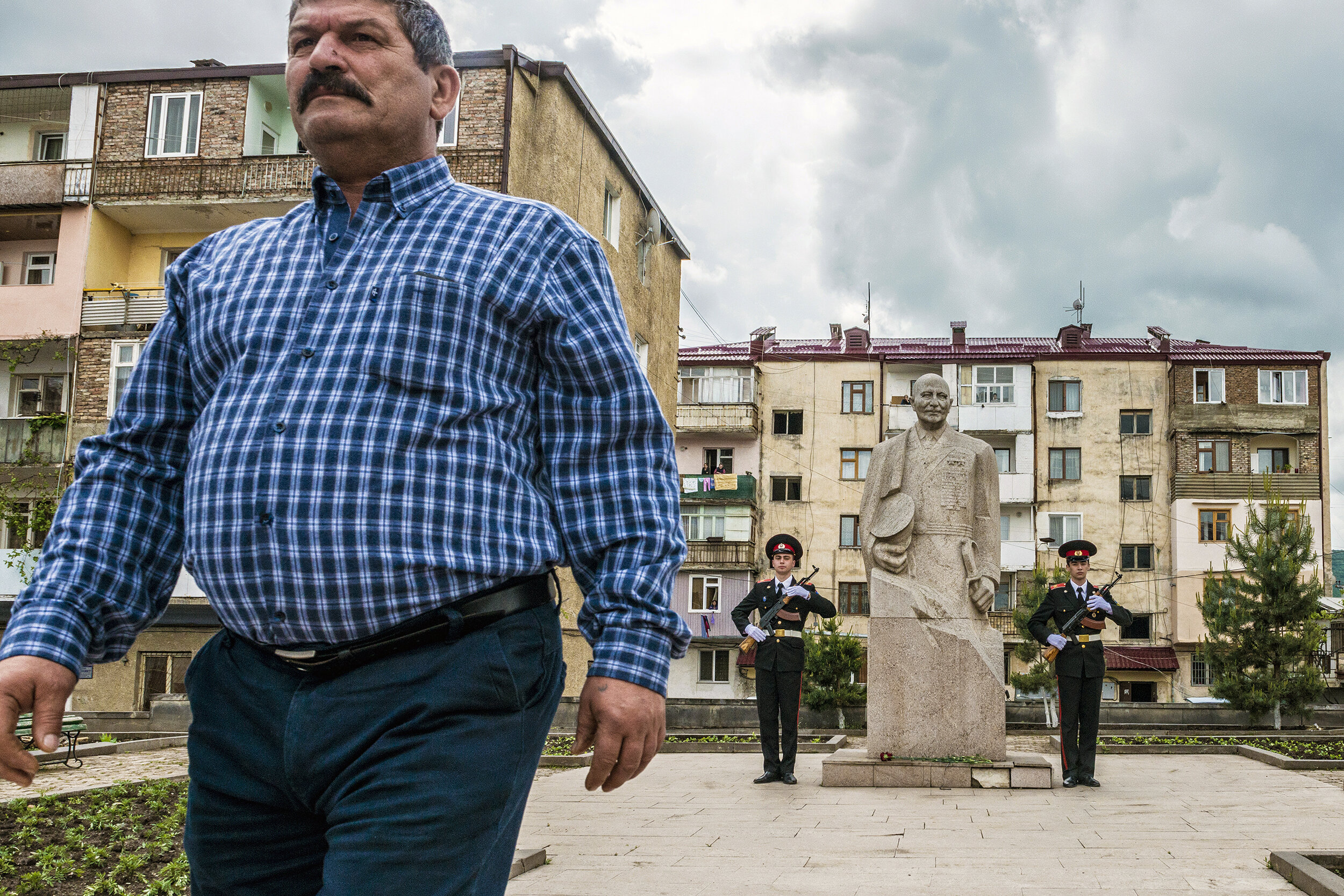  A man rejoins the annual Victory Day parade in Stepanakert, Nagorno-Karabakh after placing a rose between ceremonial guards at the foot of a statue of Ivan Bagramyan.  Bagramyan was a celebrated Soviet military commander of Armenian descent who foug