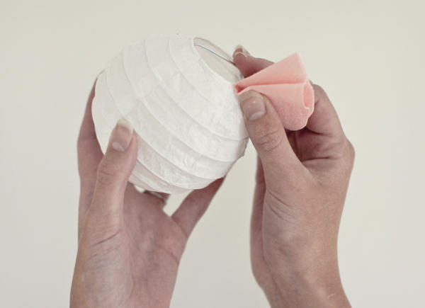 A woman Folding the circle in half and put a little hot glue on the center, then fold over to secure