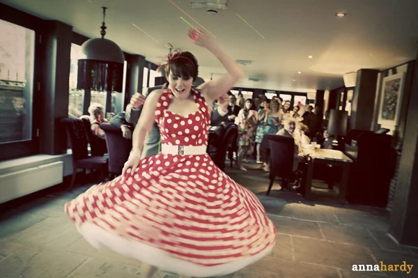 bride spinning while she’s wearing a red-white-polka-dot-dress