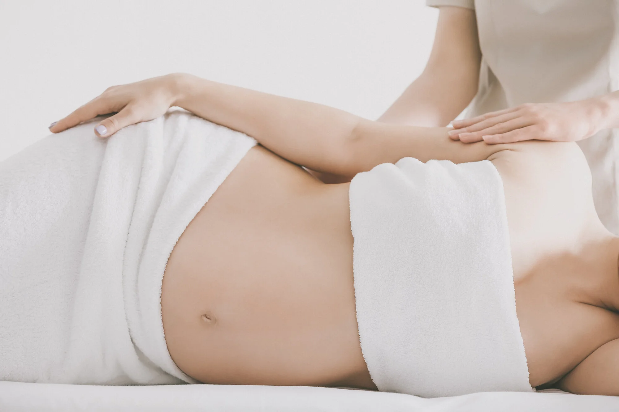 Young beautiful pregnant woman having massage in spa salon
