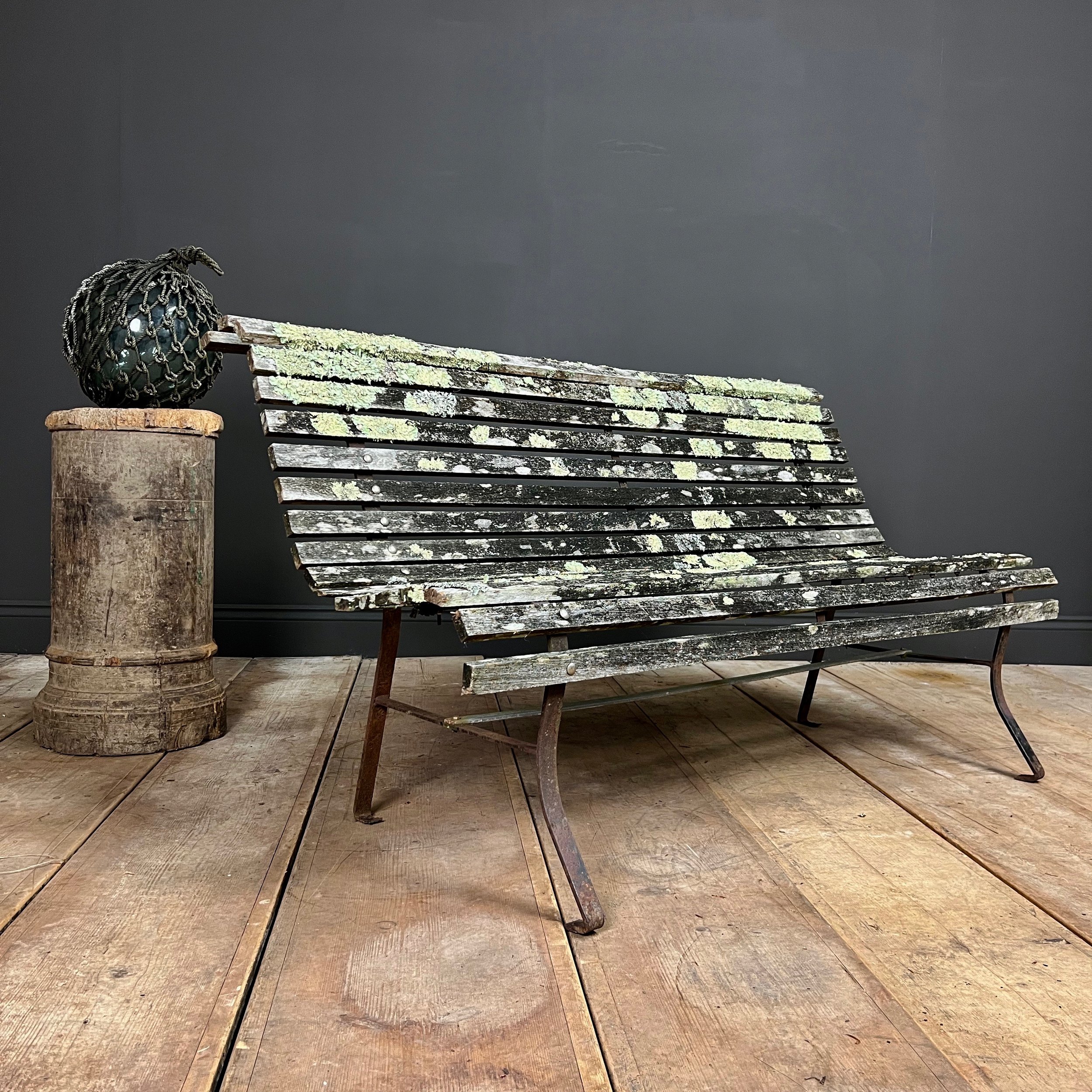 Fine example of a period scrolling garden bench wonderfully camouflaged with forest lichen