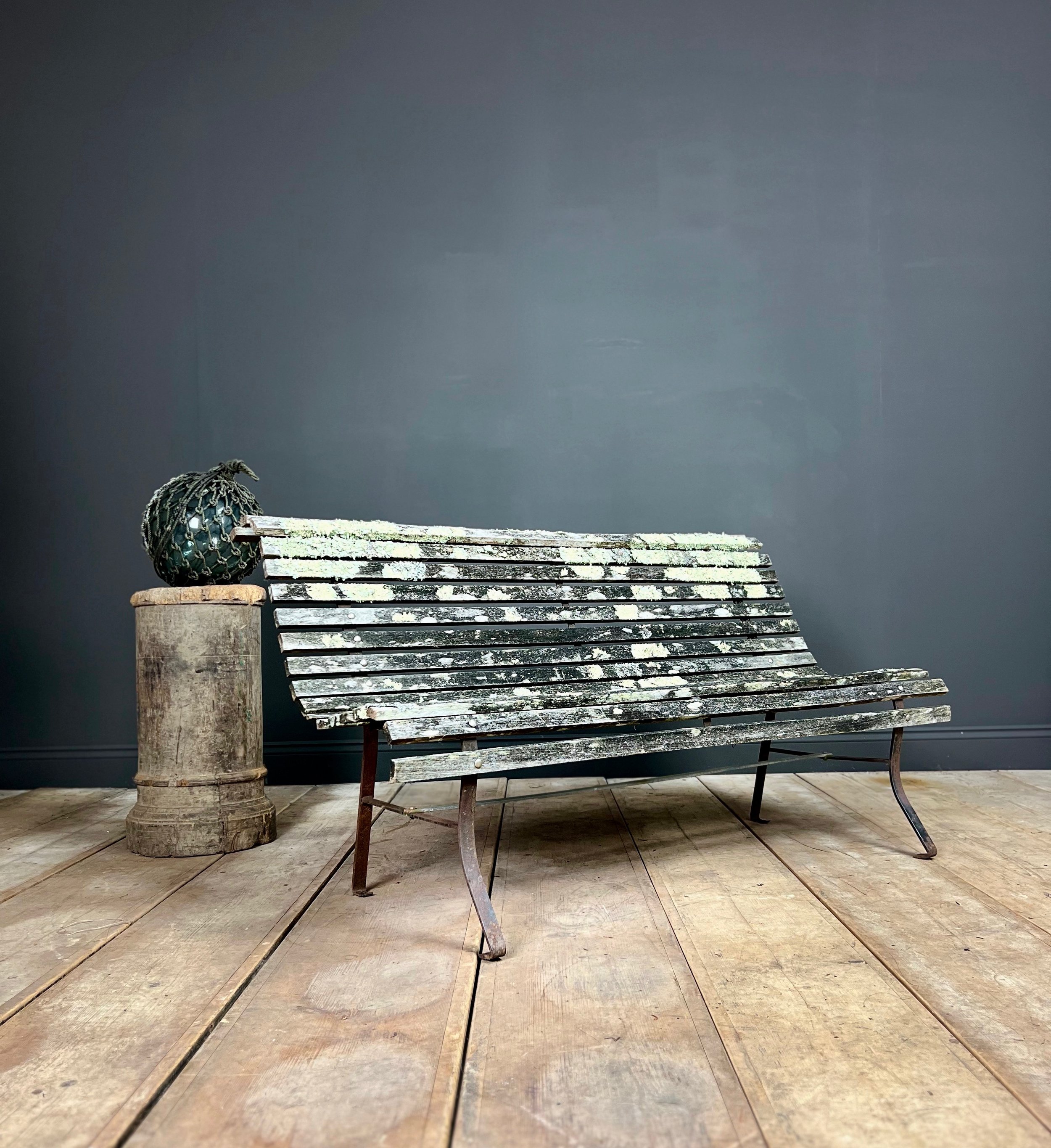 Fine example of a period scrolling garden bench wonderfully camouflaged with forest lichen