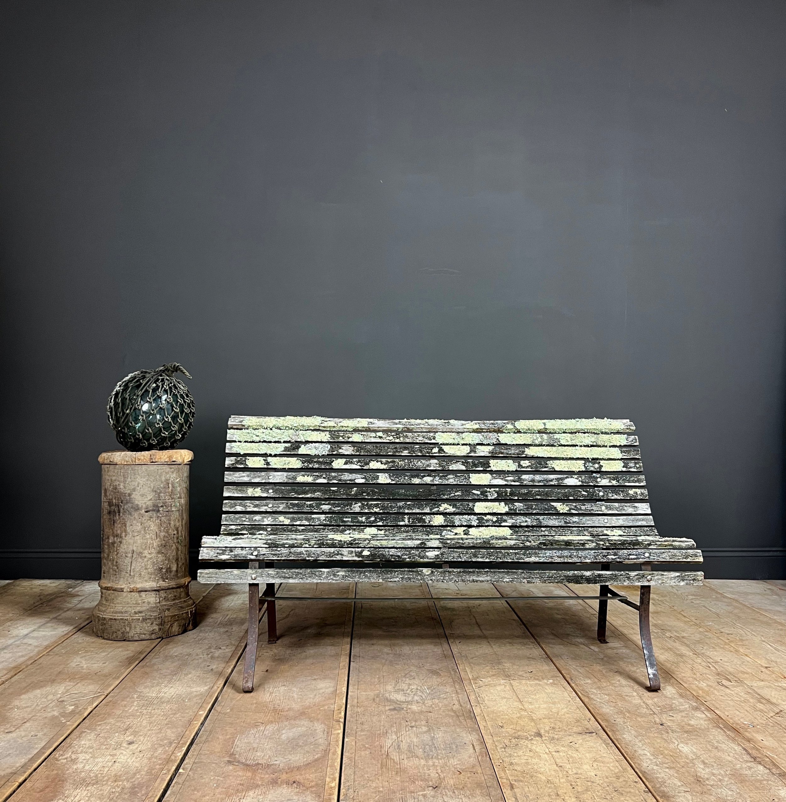 Fine example of a period scrolling garden bench wonderfully camouflaged with forest lichen