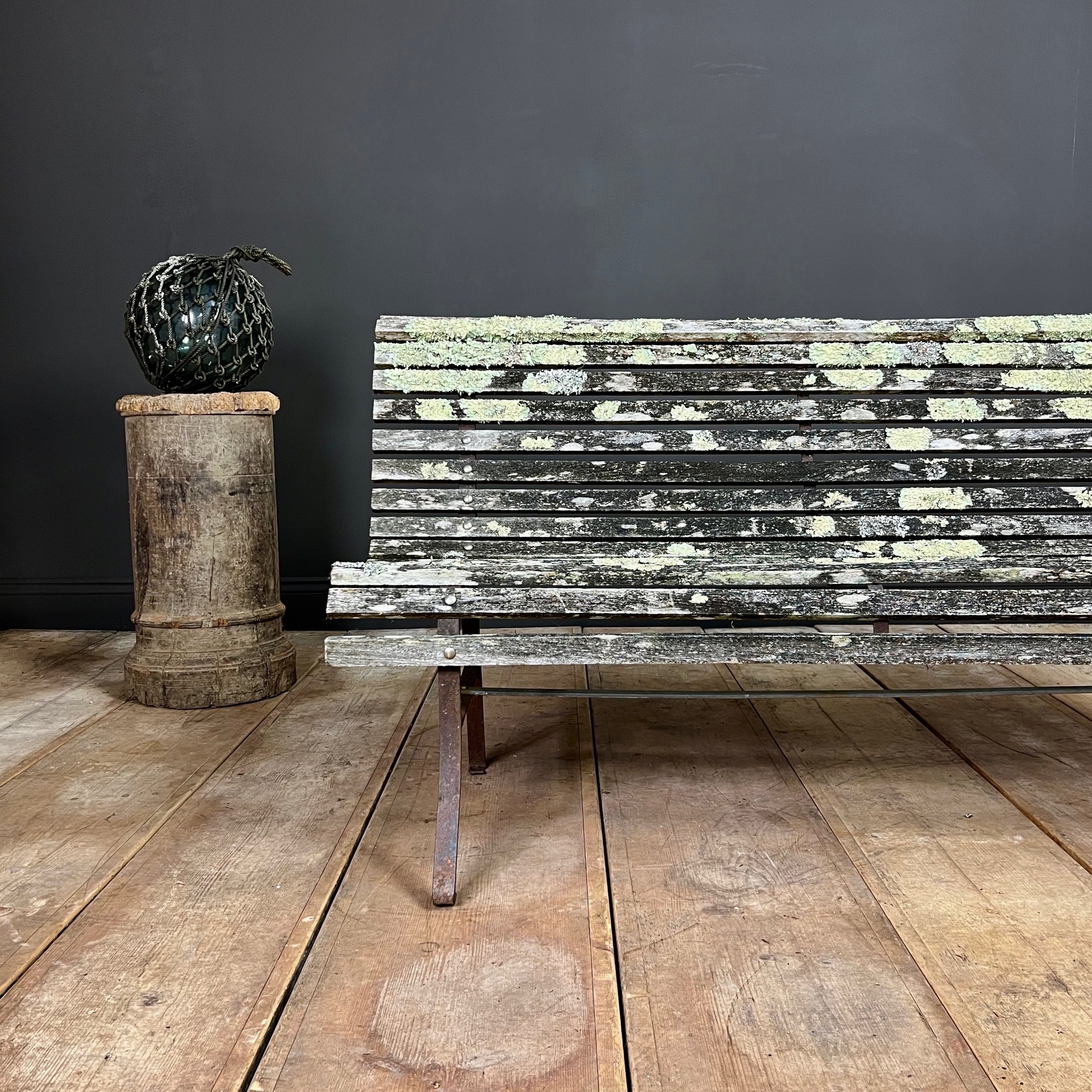 Fine example of a period scrolling garden bench wonderfully camouflaged with forest lichen
