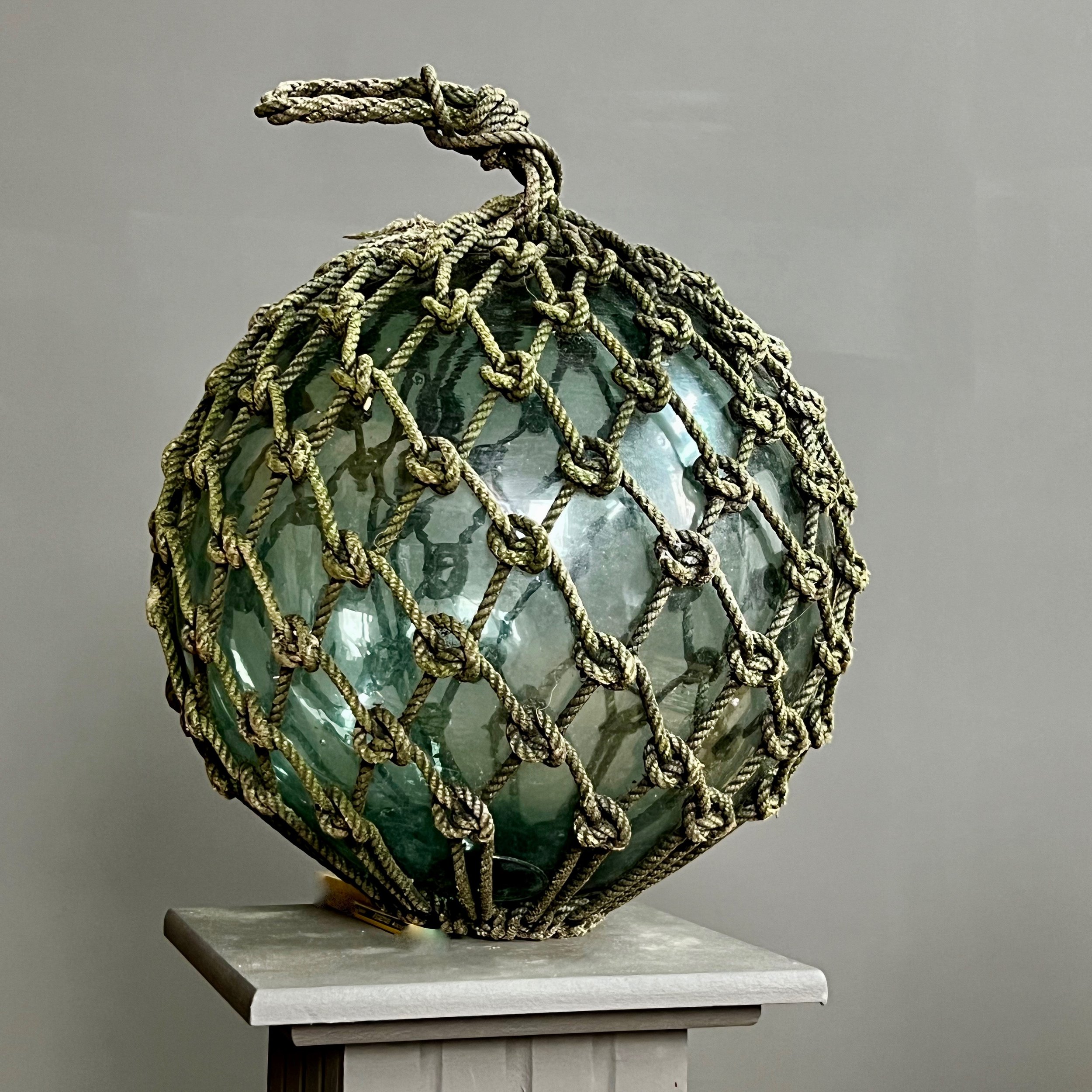 Pair of large glass and rope fishing buoys.