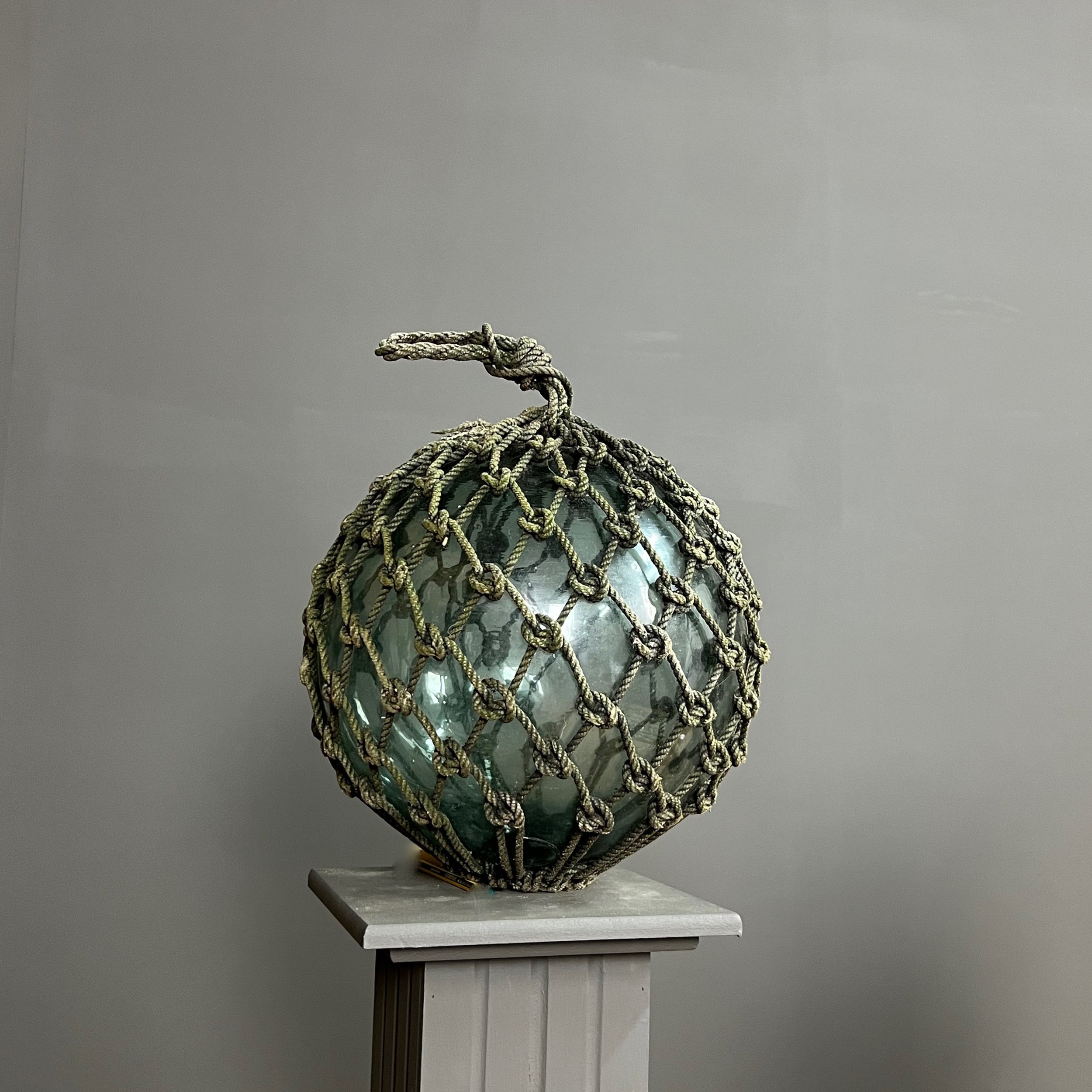 Pair of large glass and rope fishing buoys.