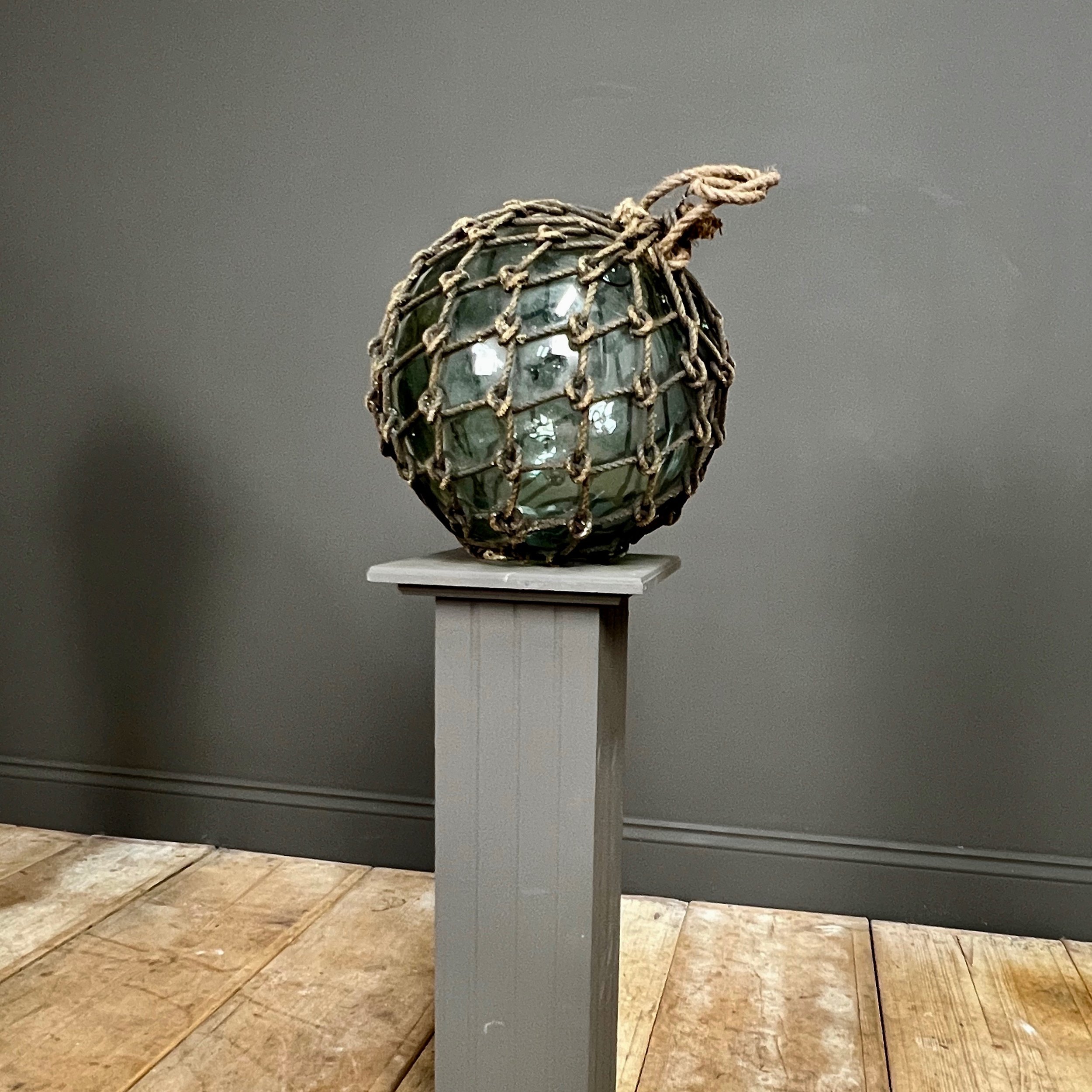 Pair of large glass and rope fishing buoys.