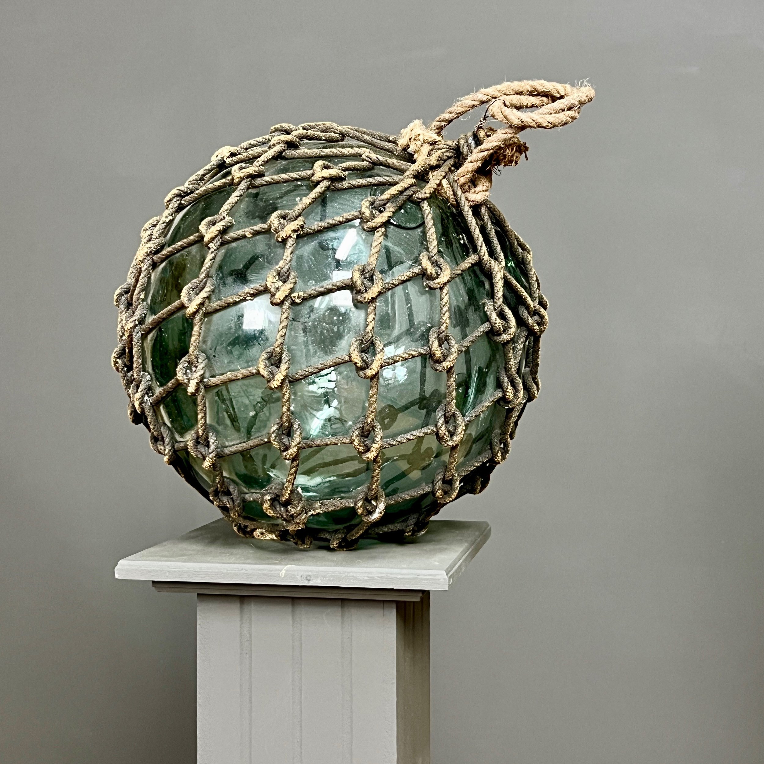 Pair of large glass and rope fishing buoys.