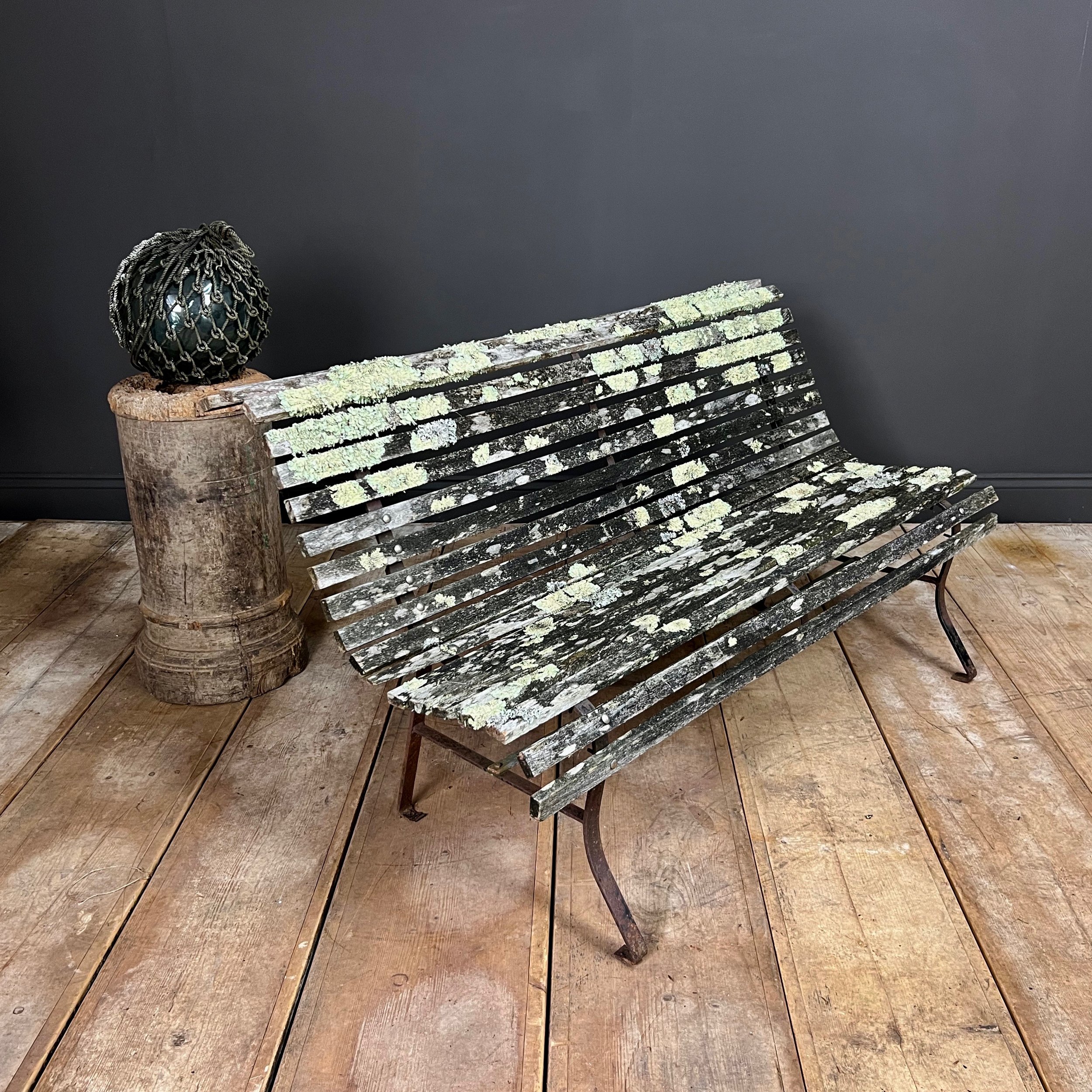 Fine example of a period scrolling garden bench wonderfully camouflaged with forest lichen