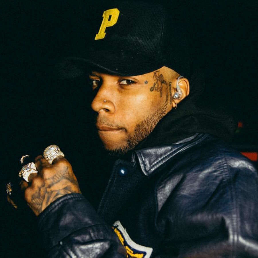 tory-lanez-wearing-a-black-and-yellow-leather-varisty-jacket-and-a-black-hat-with-a-yellow-letter-p.jpg