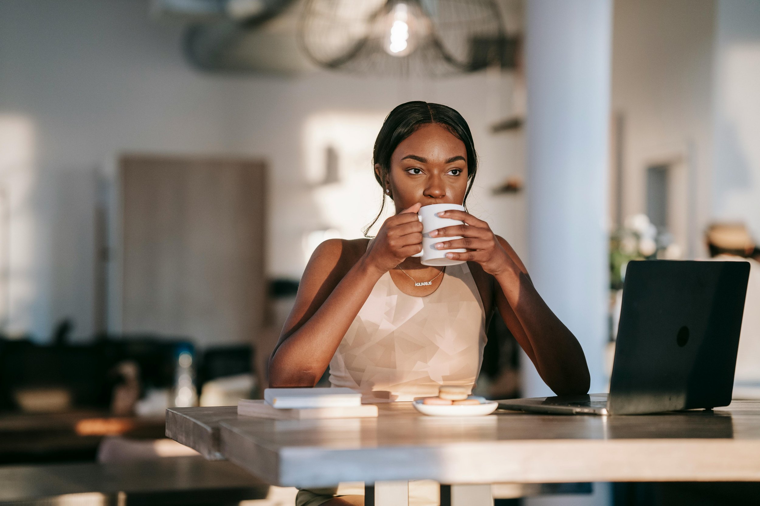 Black woman sitting at a table with a laptop — individual therapy for women in Katy TX