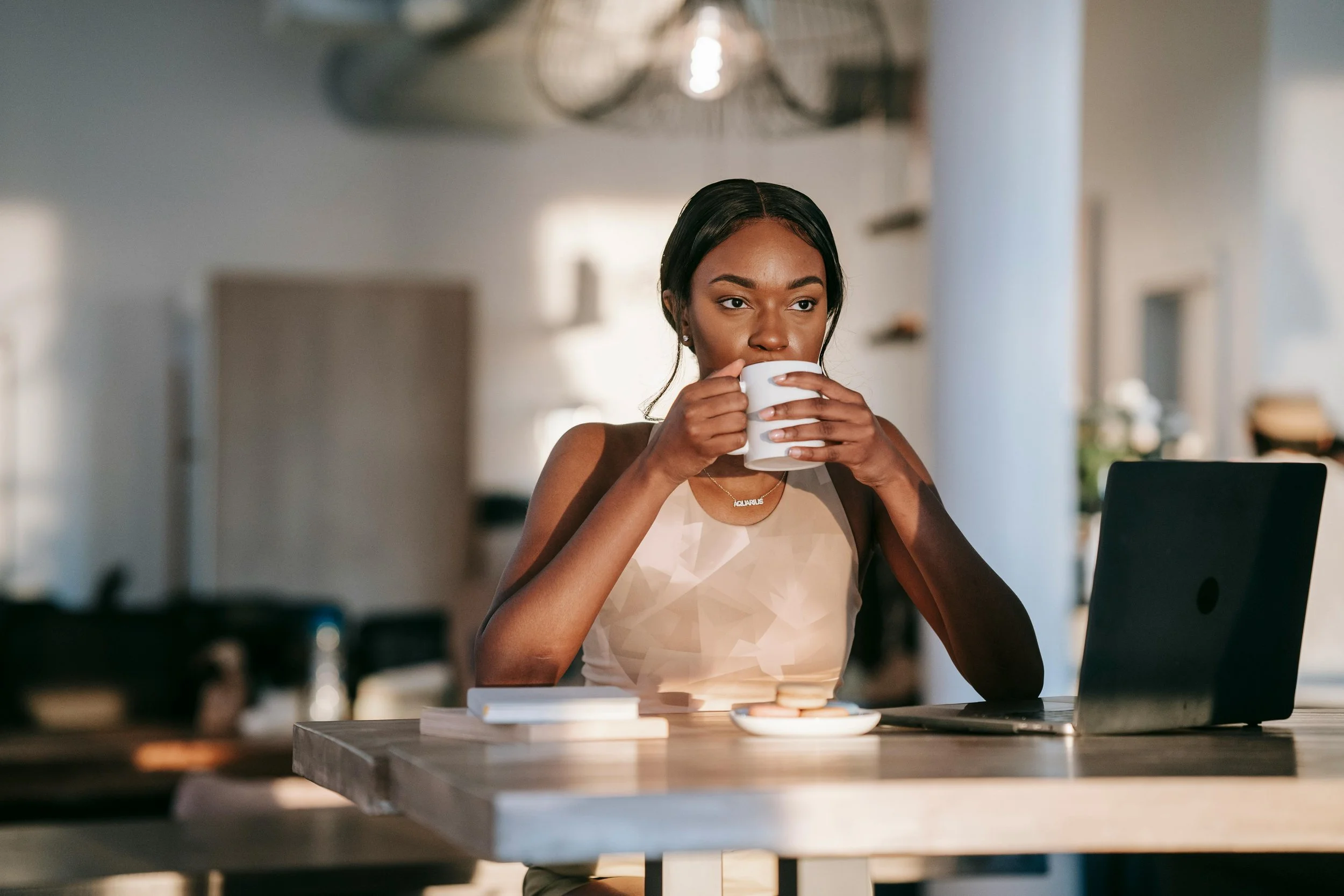 Black woman sitting at a table with a laptop — individual therapy for women in Houston TX