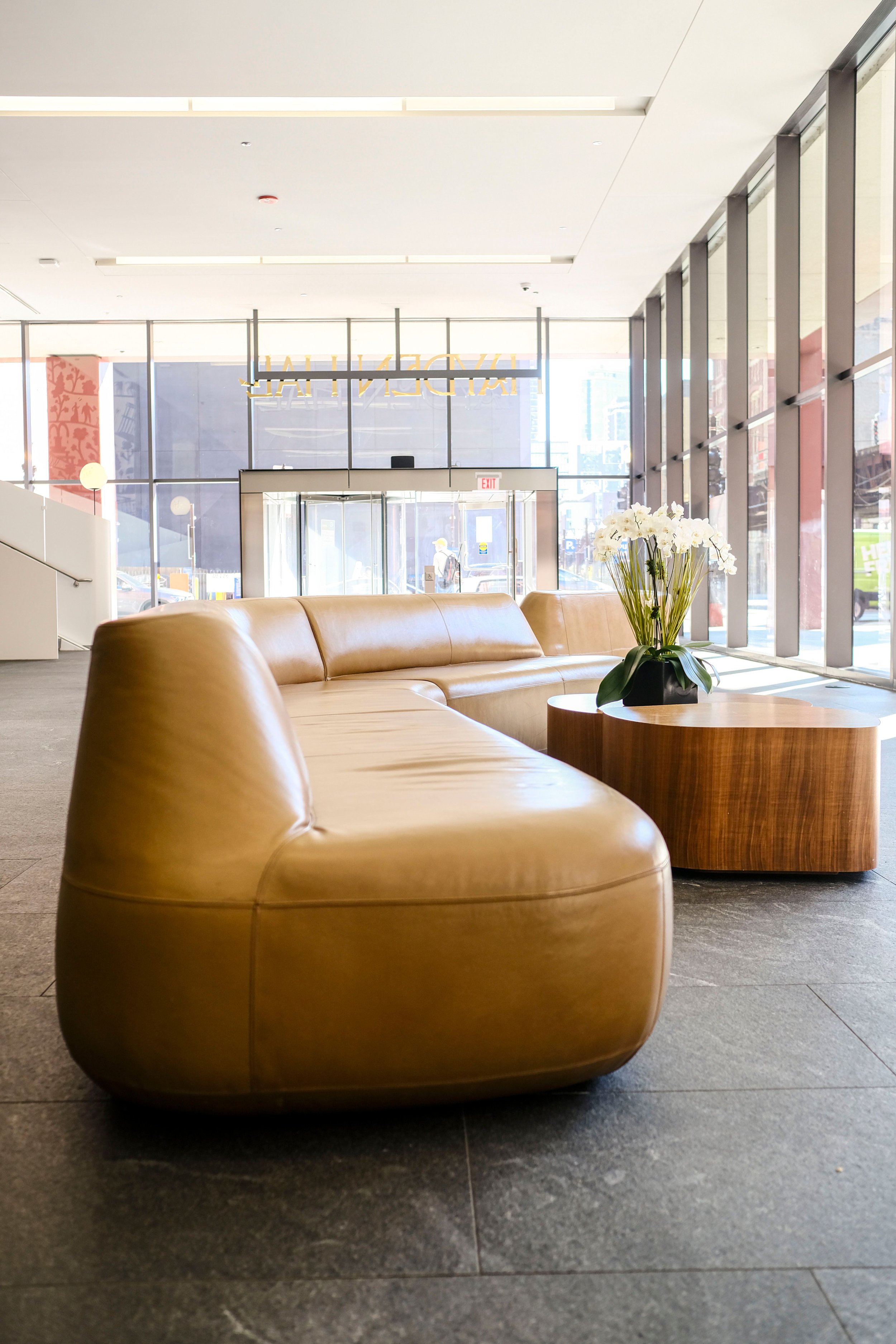 Sunlit modern lobby with a curved leather sofa, welcoming couples coaching and therapy referrals in Houston, TX