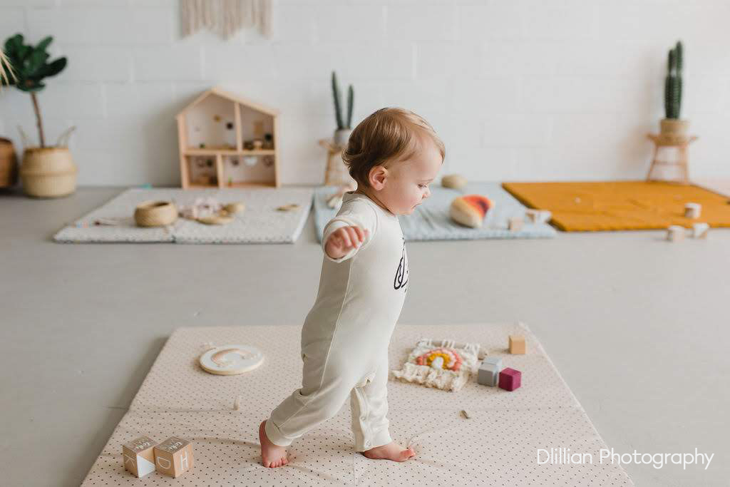 baby walking across a play mat in natural light studio in danville ca.jpg