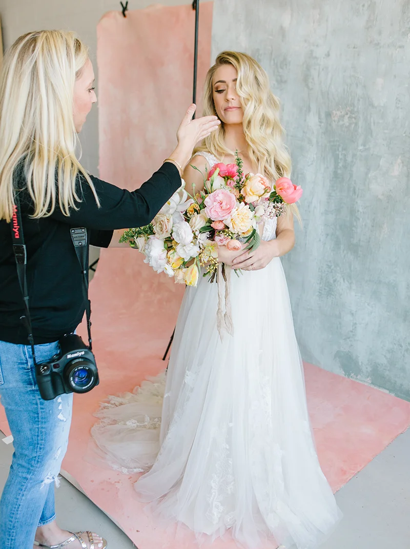 portrait photographer directing bridal model in front of a pink custom painted backdrop in a natural light studio in livermore ca.jpg