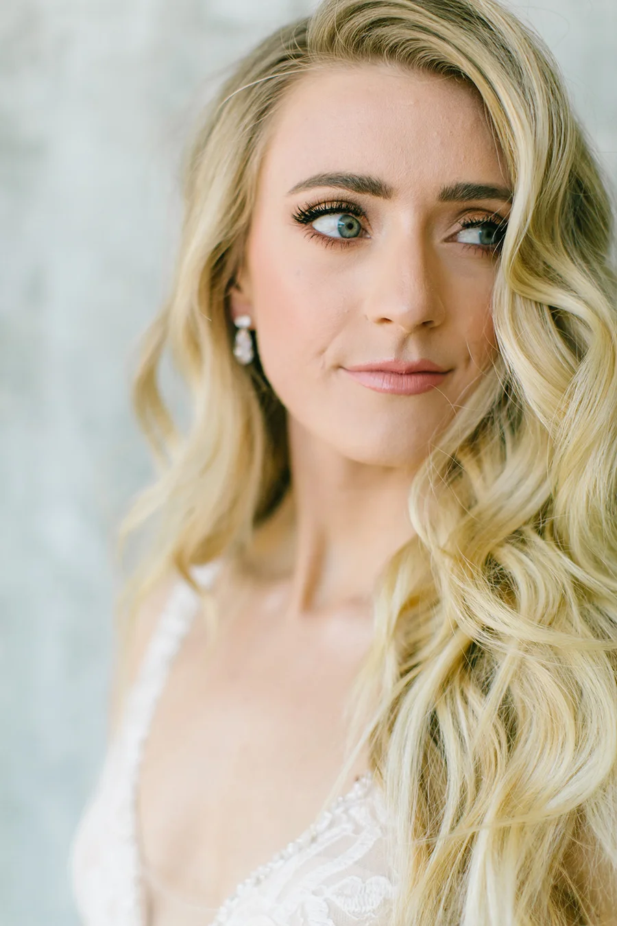 model in white wedding gown in front of grey custom painted backdrop in natural light studio in livermore ca.jpg
