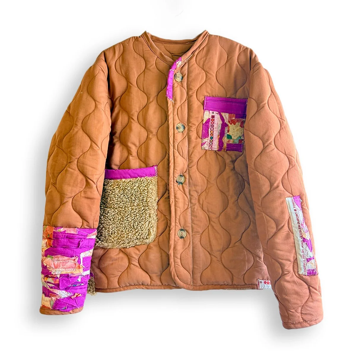 CAMP BLANKET JACKET
 
 
One-of-one jacket reworked from a vintage quilted camping blanket, combining its worn-in utility fabric with contrasting Sherpa and custom patchworked textiles made from floral and purple fabric scraps. Finished with an oversi