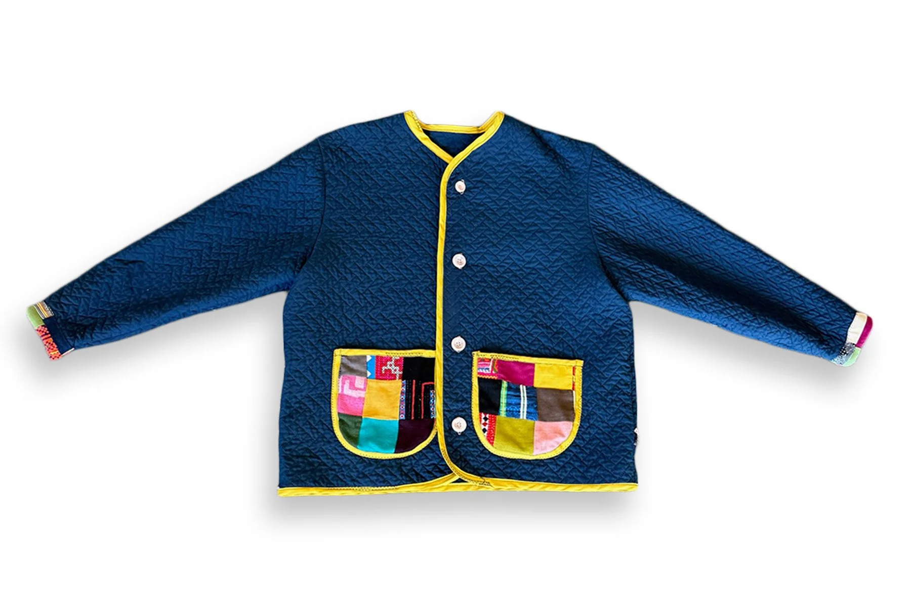 HMONG JACKET
 
 
One-of-one navy quilted jacket featuring Hmong textiles sourced in Chiang Mai, Thailand, with bright yellow binding and patchwork pockets. Finished with contrasting buttons, textile details at the cuffs, and raw-edge strips across th