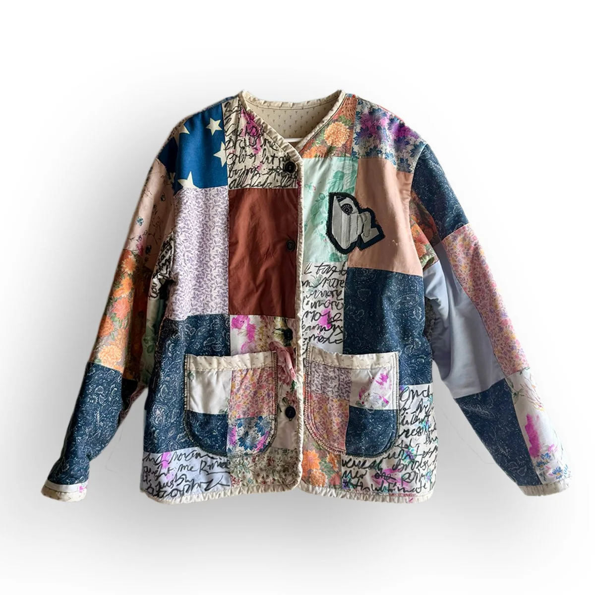 CURSIVE JACKET
 
 
One-of-one quilted jacket built from a patchwork of reclaimed floral, paisley, printed and hand-marked textiles, with appliquéd artwork worked directly into the garment. Finished with contrasting patch pockets, bound edges and mism