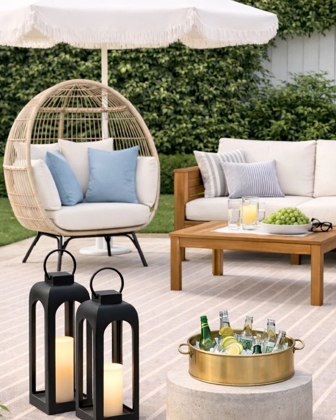 outdoor space with a whicker egg chair, black lanterns and a brass bar cooler