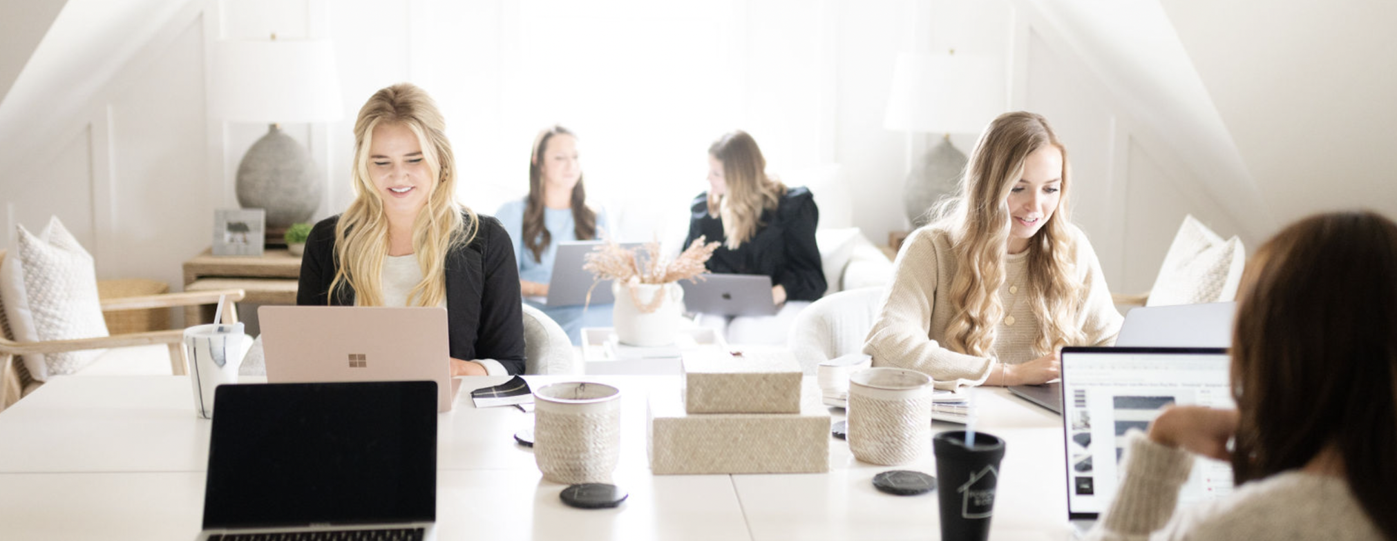 group photo of the porche and co team working on their laptops in a bright space