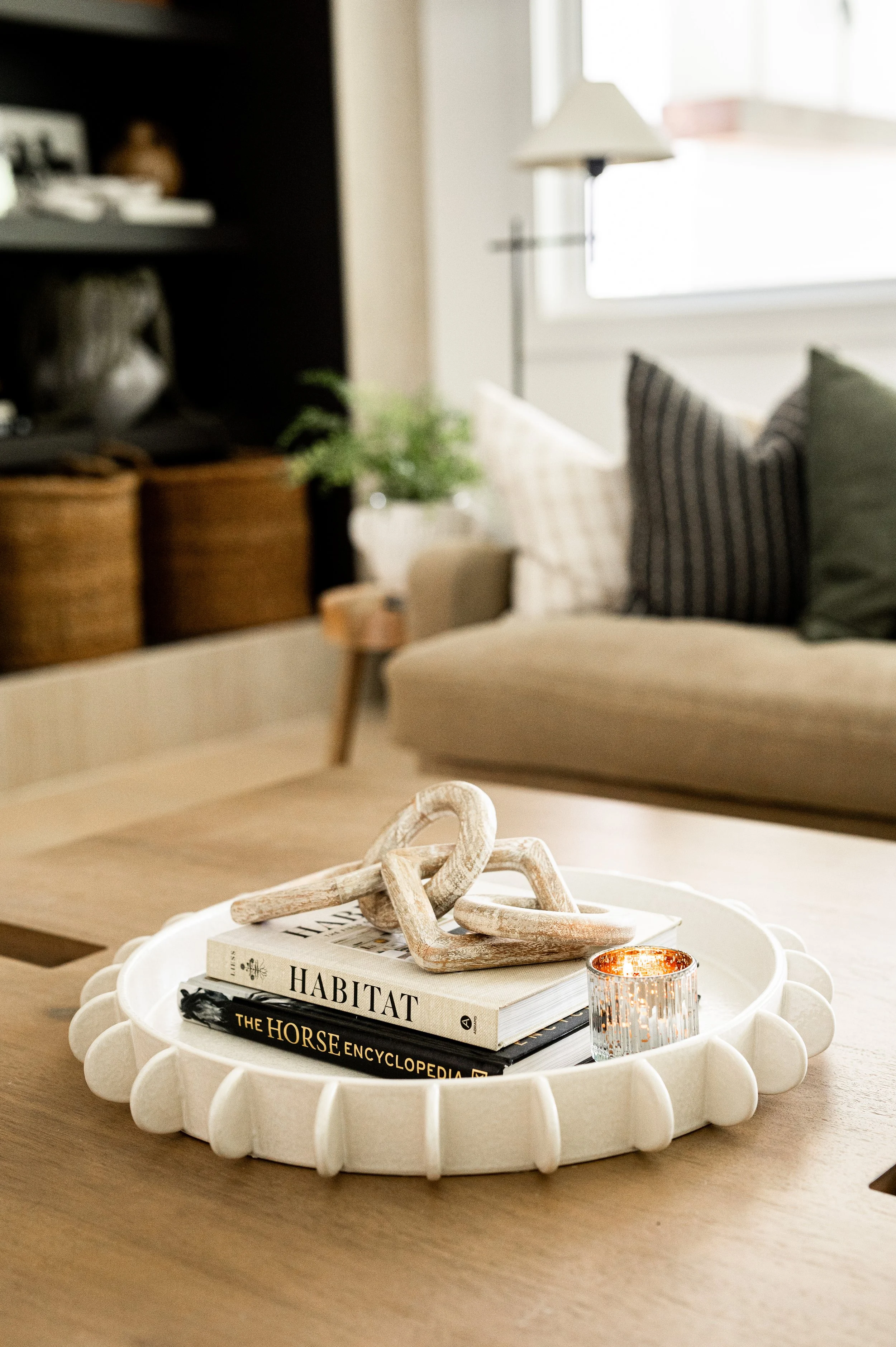 coffee table styled with white tray and wooden figure with a candle