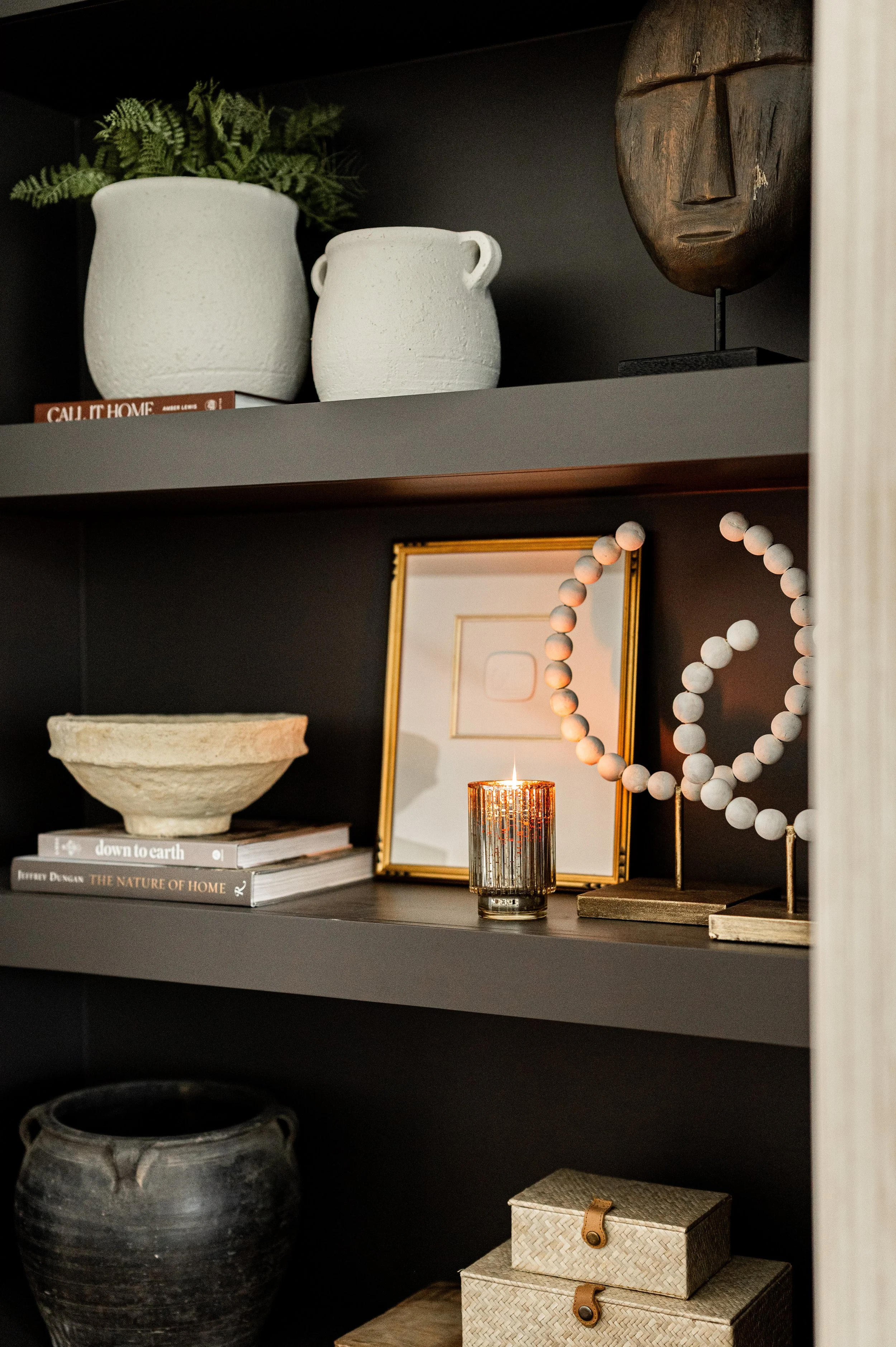 black shelves styled with modern finishes and a candle