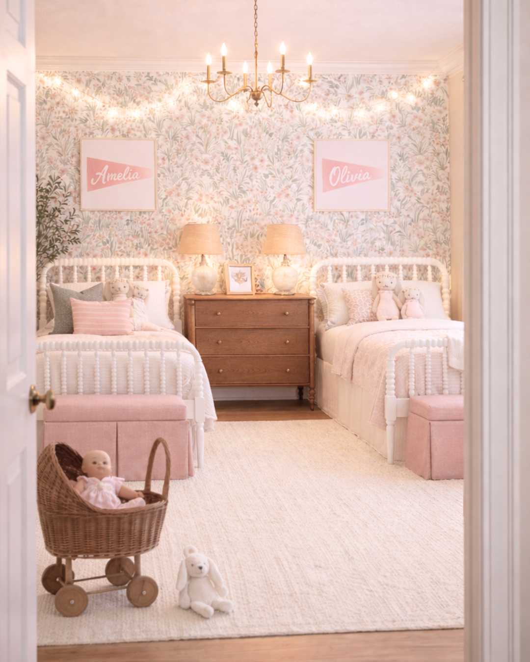 adorable little girls room with two twin beds, name flag pendants, floral wallpaper with string lights