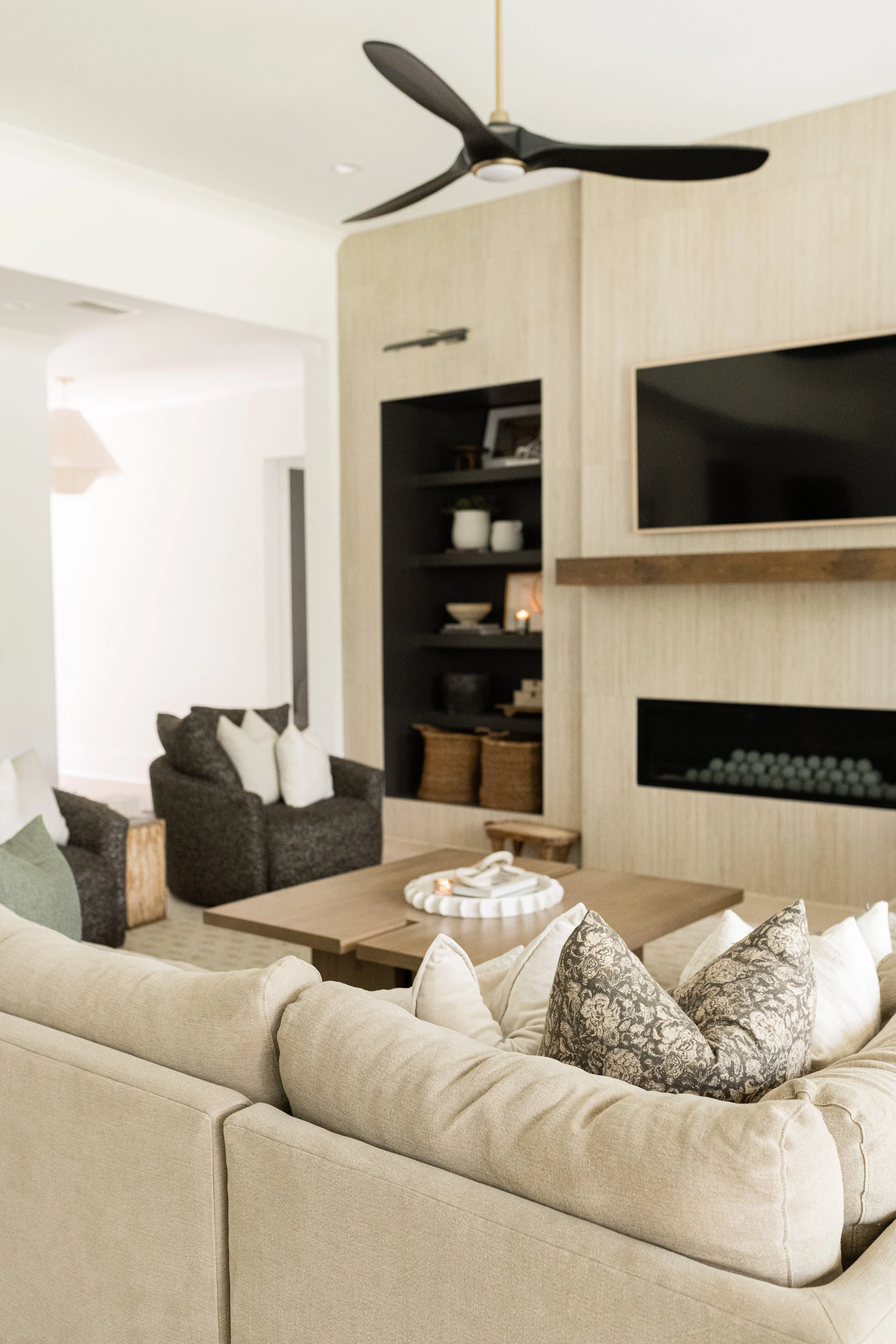 modern fireplace with tiled feature with tan couch and pillows