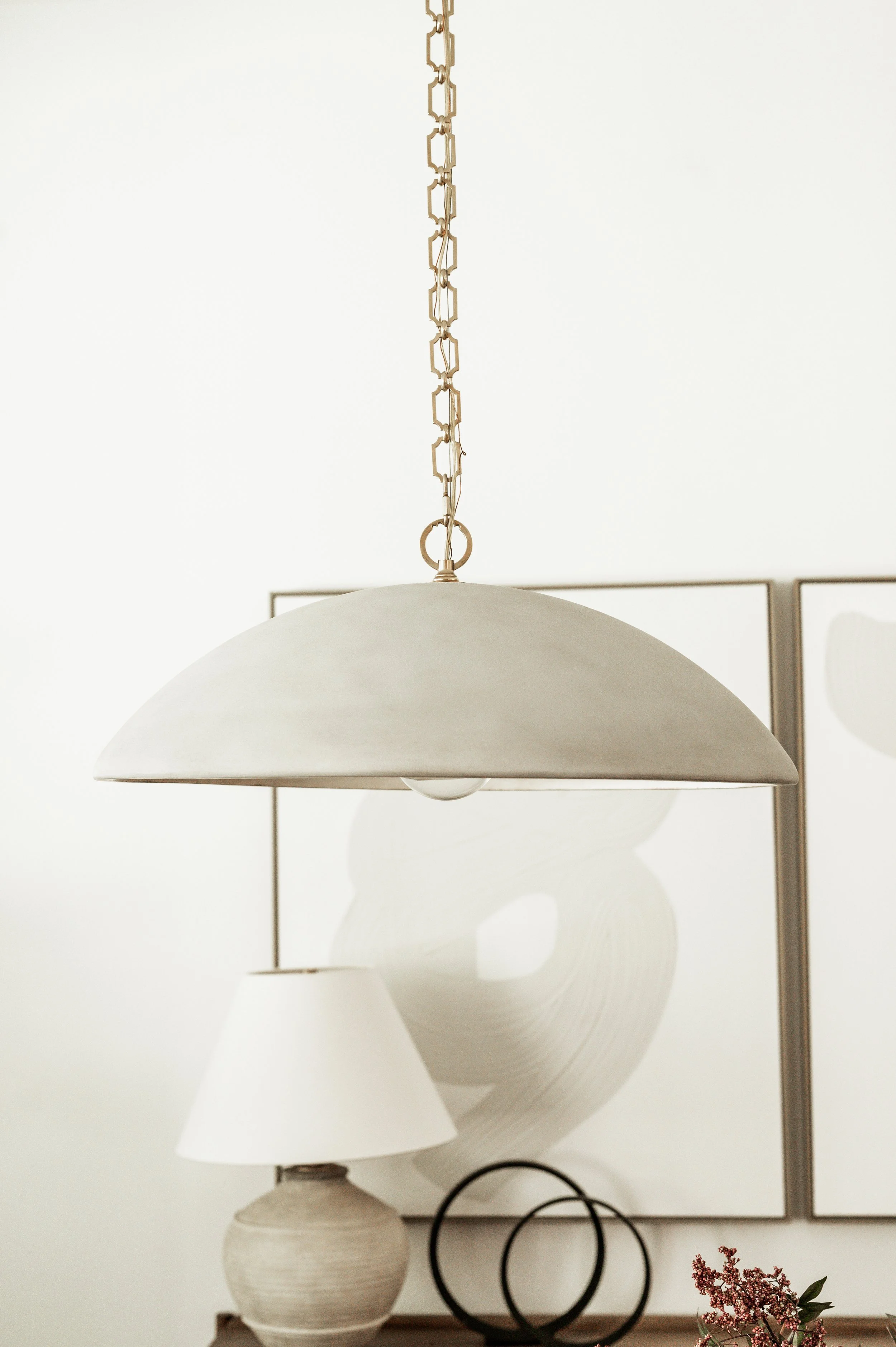 close up image of cement dining room pendant and circle decor