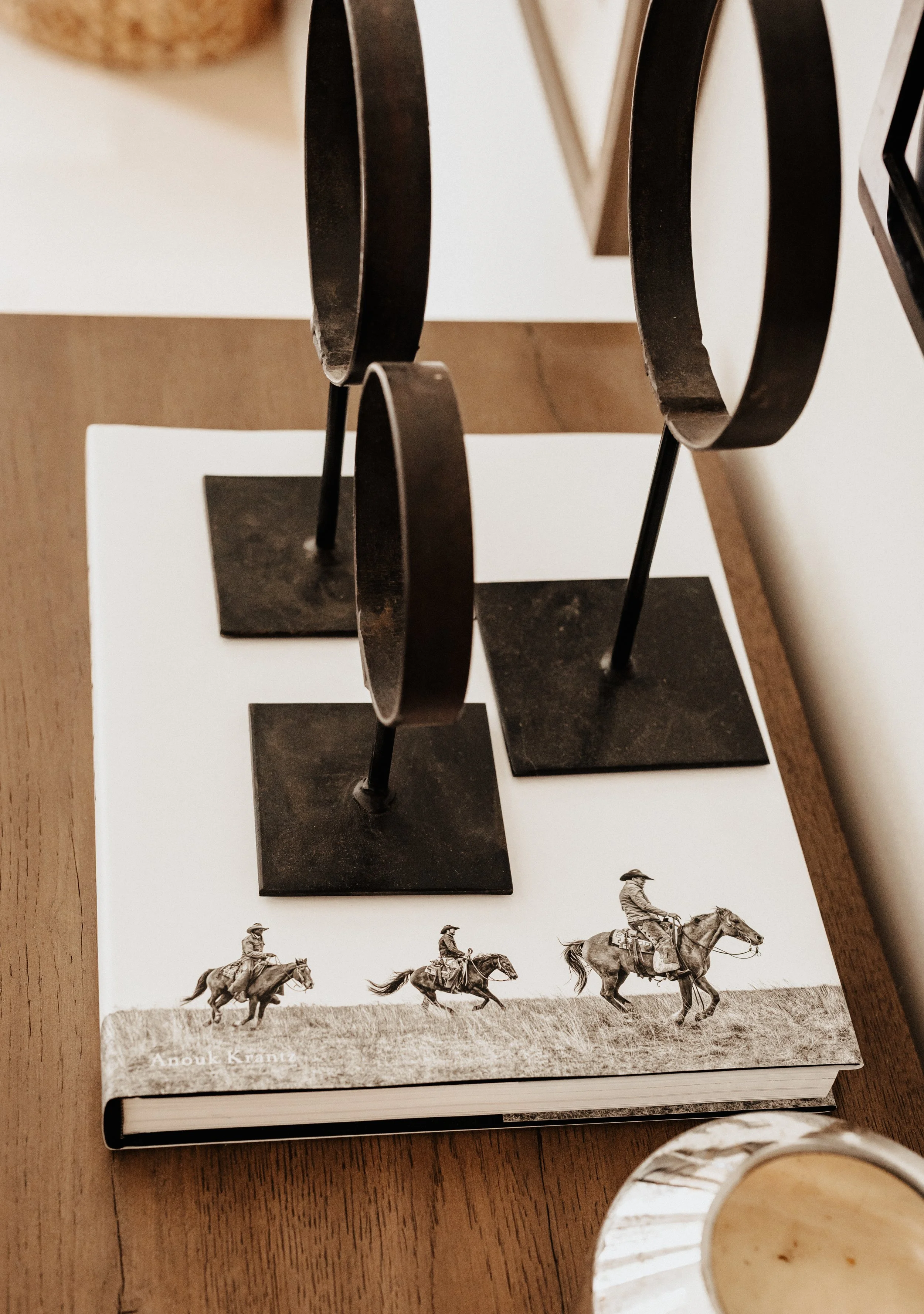 tall circle metal decor on a book on a dresser