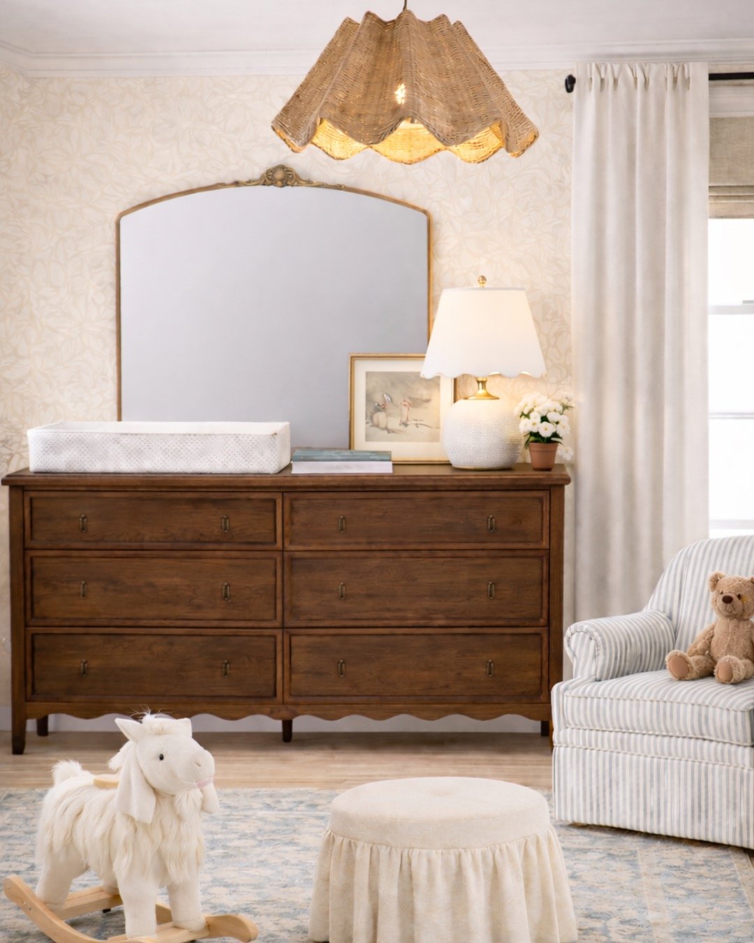 girls nursery with wooden dresser and scalloped light with wallpaper