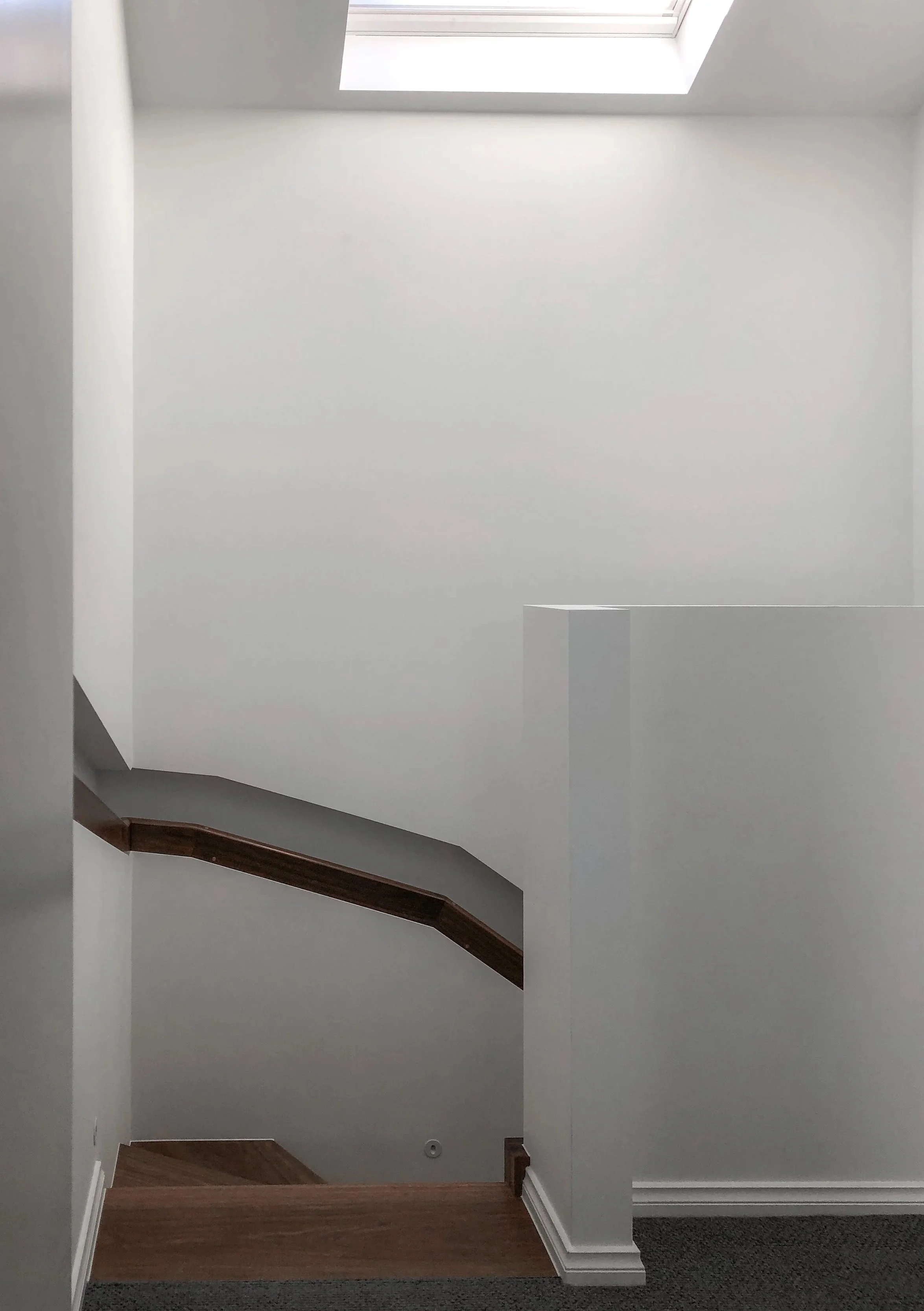 Timber stair with concealed handrail and skylight above