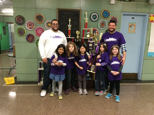 Coach Russell Makofsky, left, and coach Angel Lopez, right, with the 2016 PS 33's girls' chess team (missing 2 players).