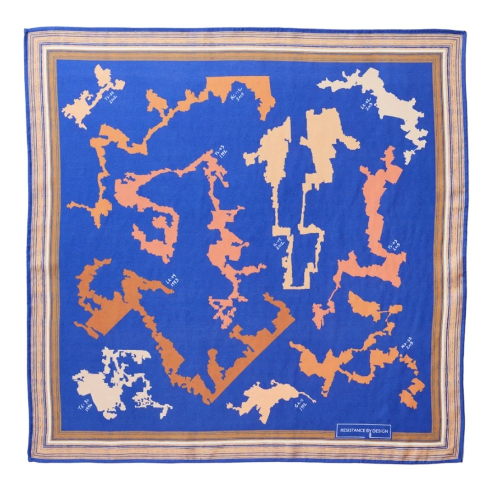 A colorful quilt with a map-like pattern in shades of orange and peach on a blue background, with a border in shades of tan, cream, and blue.