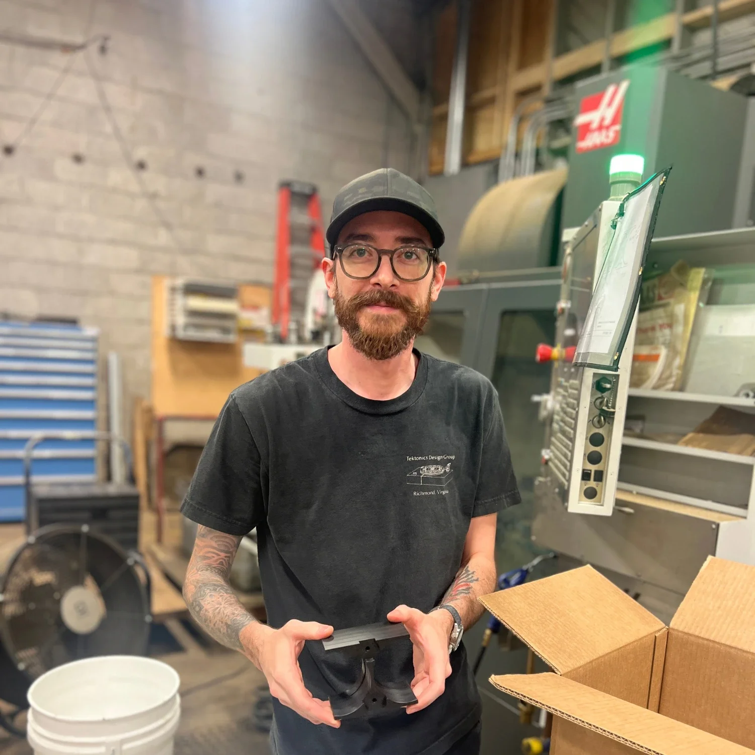 Tektonics machinist holding a finished CNC-machined acetal component.