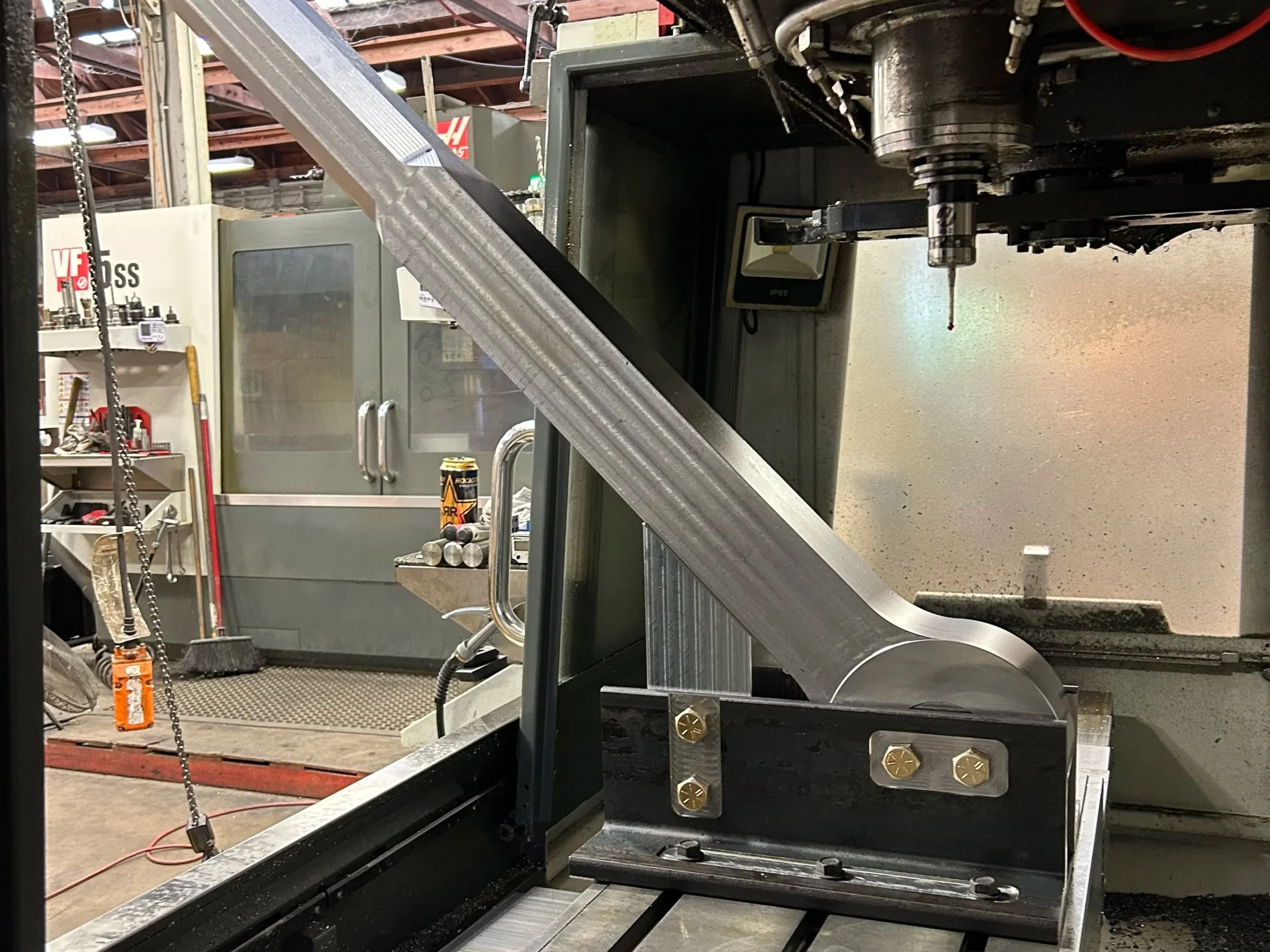 The hole needed to go through the head of the eyebolt at a 45 degree angle, so we designed a specialized fixture that supported the 200 lbs blank. This setup allowed us to accurately and repeatedly drill through all 50 eyebolts.
