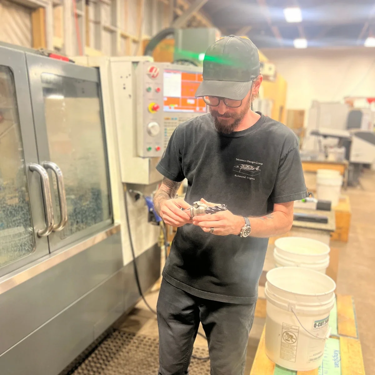 Tektonics machinist holding CNC machining tools in a Richmond machine shop.