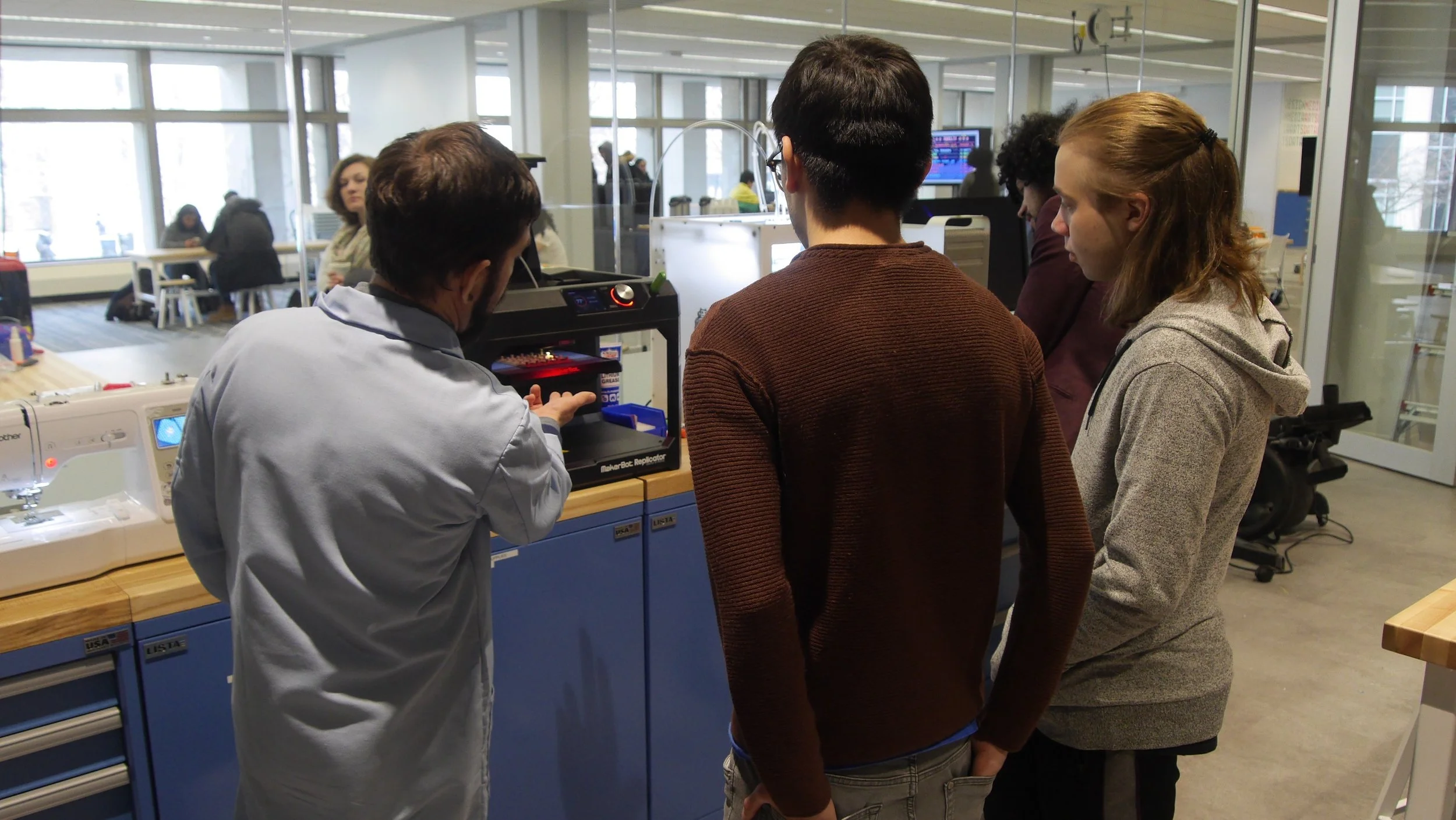 Lambert shows students how to use a 3-D printer in HAL. Photo by Robert Mitchum.